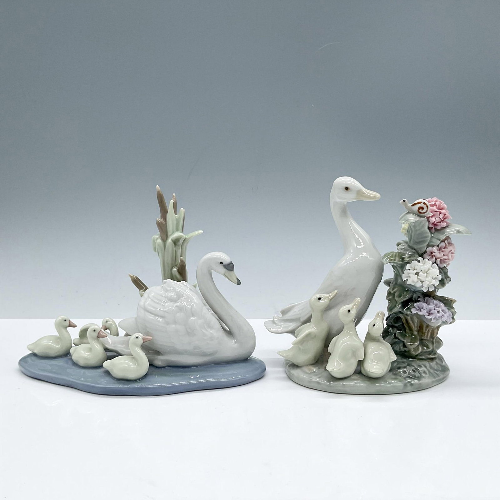 2pc Follow Me & How You Do - Lladro Porcelain Figurines: Glazed finish. This duo features adorable scenes of mother Duck and Swan with their babies. Includes: Follow Me 1005722, signed and stamped with Lladro mark. Sculpted by Antonio Ramos; How You Do! 100