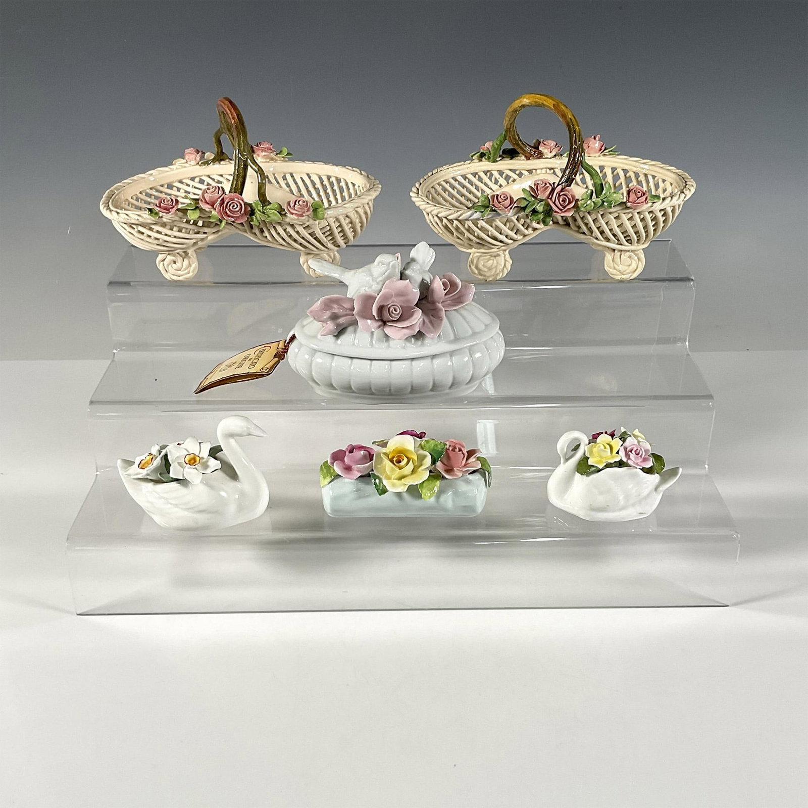 6pc Group Of European Baskets And Birds Figurines: Made in England and Germany. Baskets are light tan with pink roses. Container with two birds and pink roses on the lid. Two swan figurines with hand painted flowers sprouting from their backs. Light-c