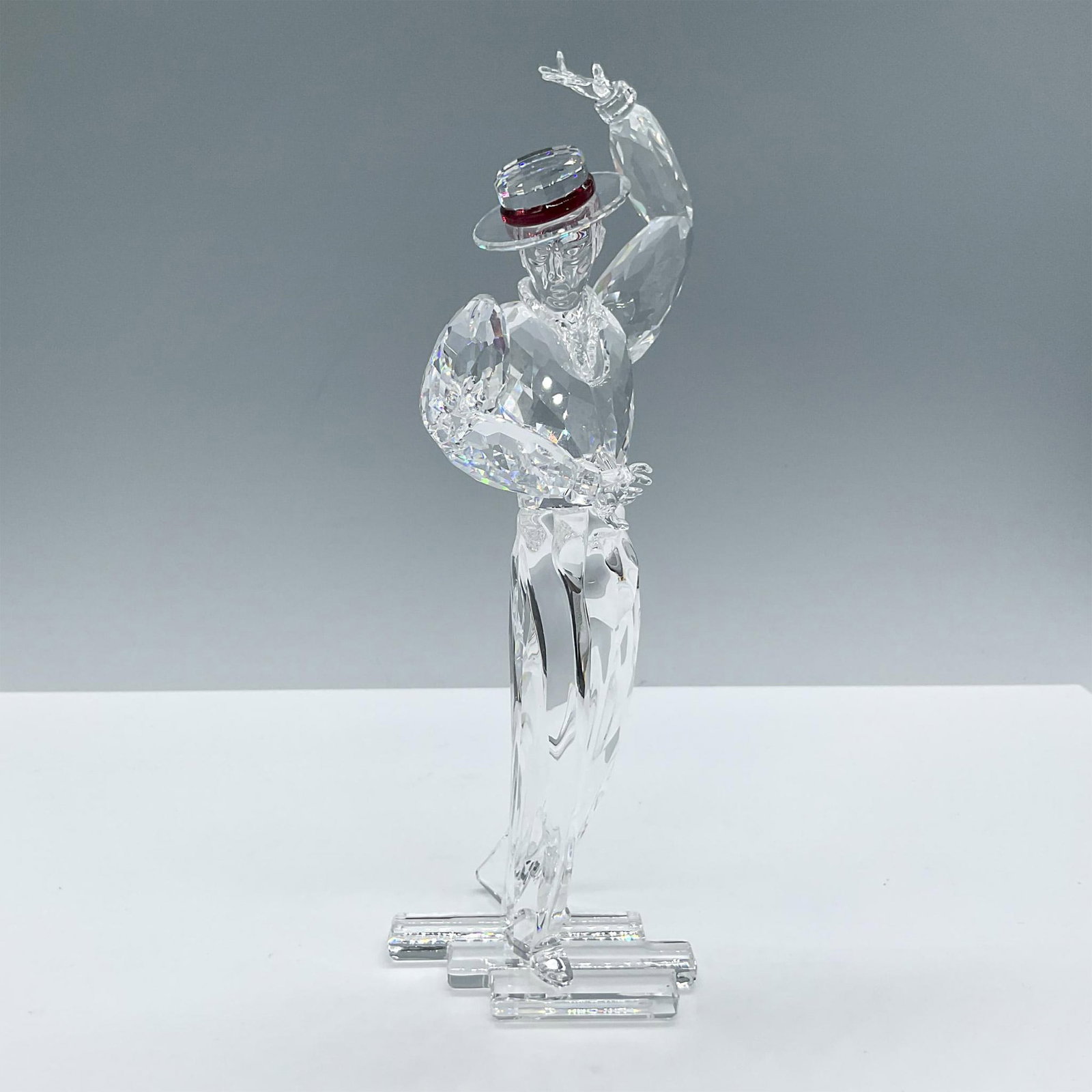 Swarovski Crystal Figurine, Magic of Dance Antonio 2003: The second piece in the Magic of Dance Trilogy, crafted from clear faceted crystal, featuring a red crystal adorning his hat. Includes the certificate and the original box, dimensions: 11.25''L x 6.5'