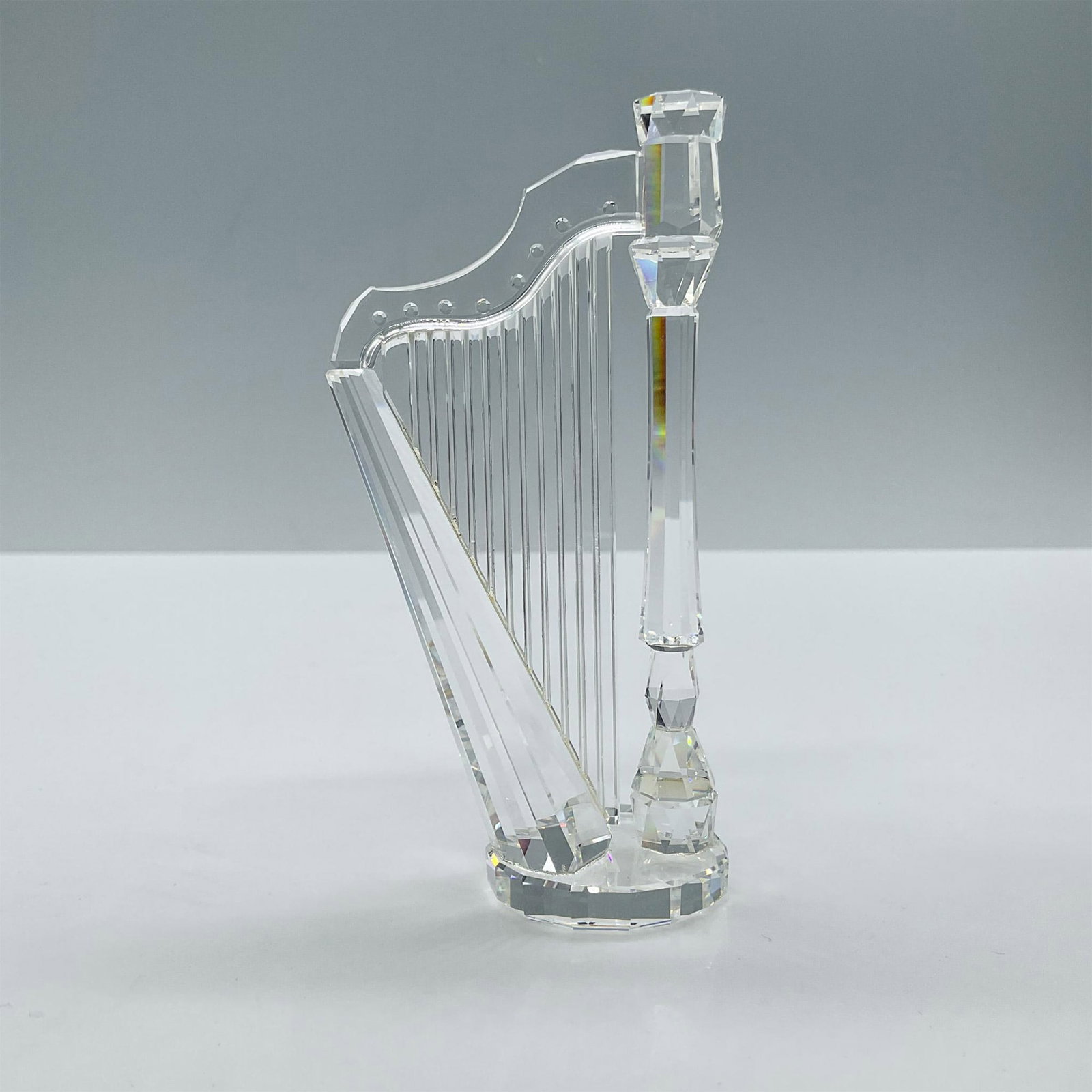 Swarovski Crystal Figurine, Harp: Full lead clear crystal. Part of the Crystal Melodies collection. Includes the certificate and the original box, dimensions: 6''H x 5''dia. Swarovski backstamp. Artist: Martin Zendron Issued: 1998 Dim