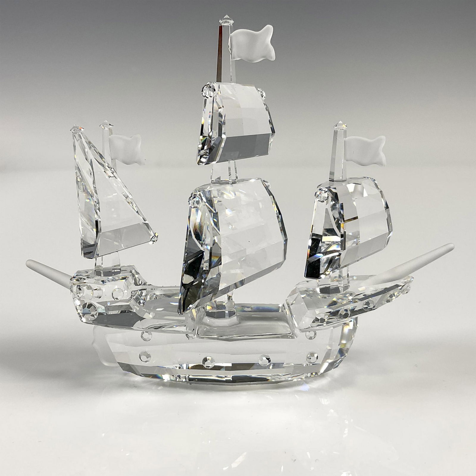 Swarovski Silver Crystal Figurine, Santa Maria: Beautiful clear sea vessel with small, frosted sails and ship bow. Displayed on mirrored base. Swarovski backstamp.7473 NR 000 003. This item has its original box: 7.5"L x 8"W x 6"H. Artist: Gabriele