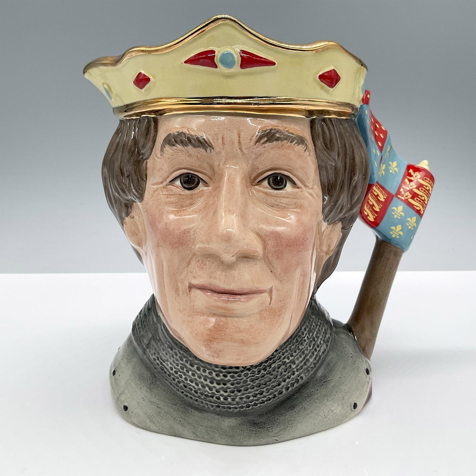 Henry V D6671 (Non Embossed) - Large - Royal Doulton Character Jug: Style One, Variation Three. Yellow crown with gold, blue and red design. Royal Doulton backstamp. Artist: Robert Tabbenor Issued: c. 1984 - 1989 Dimensions: 7.25"H Manufacturer: Royal Doulton Country 
