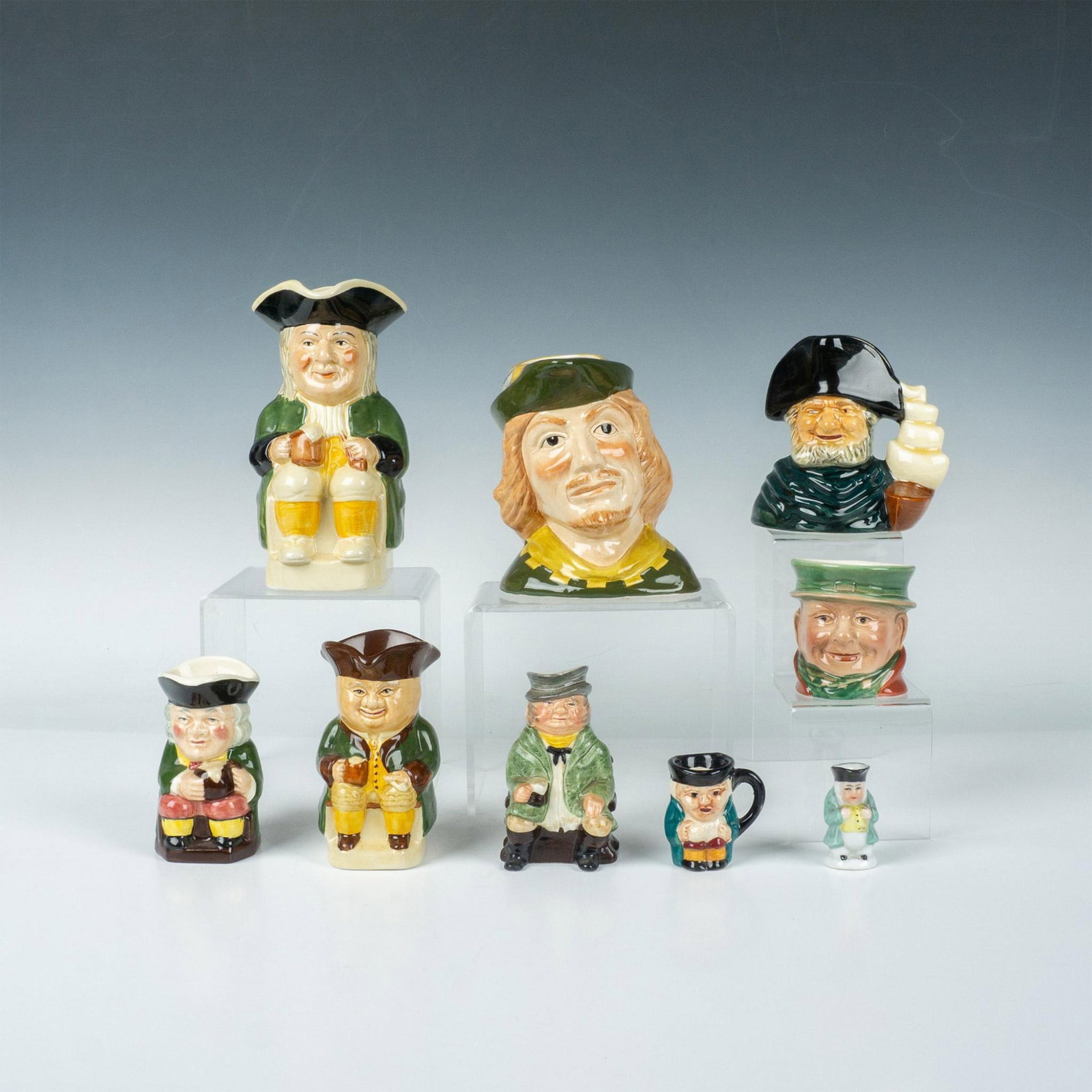 9pc Vintage Toby Jug Grouping, Green Hued: This hand-decorated toby jug grouping was primarily made in England with the exception of a small, unmarked piece believed to be made in Japan. The largest piece measures 5.75"L x 3.75"W x 7"H. Dimens