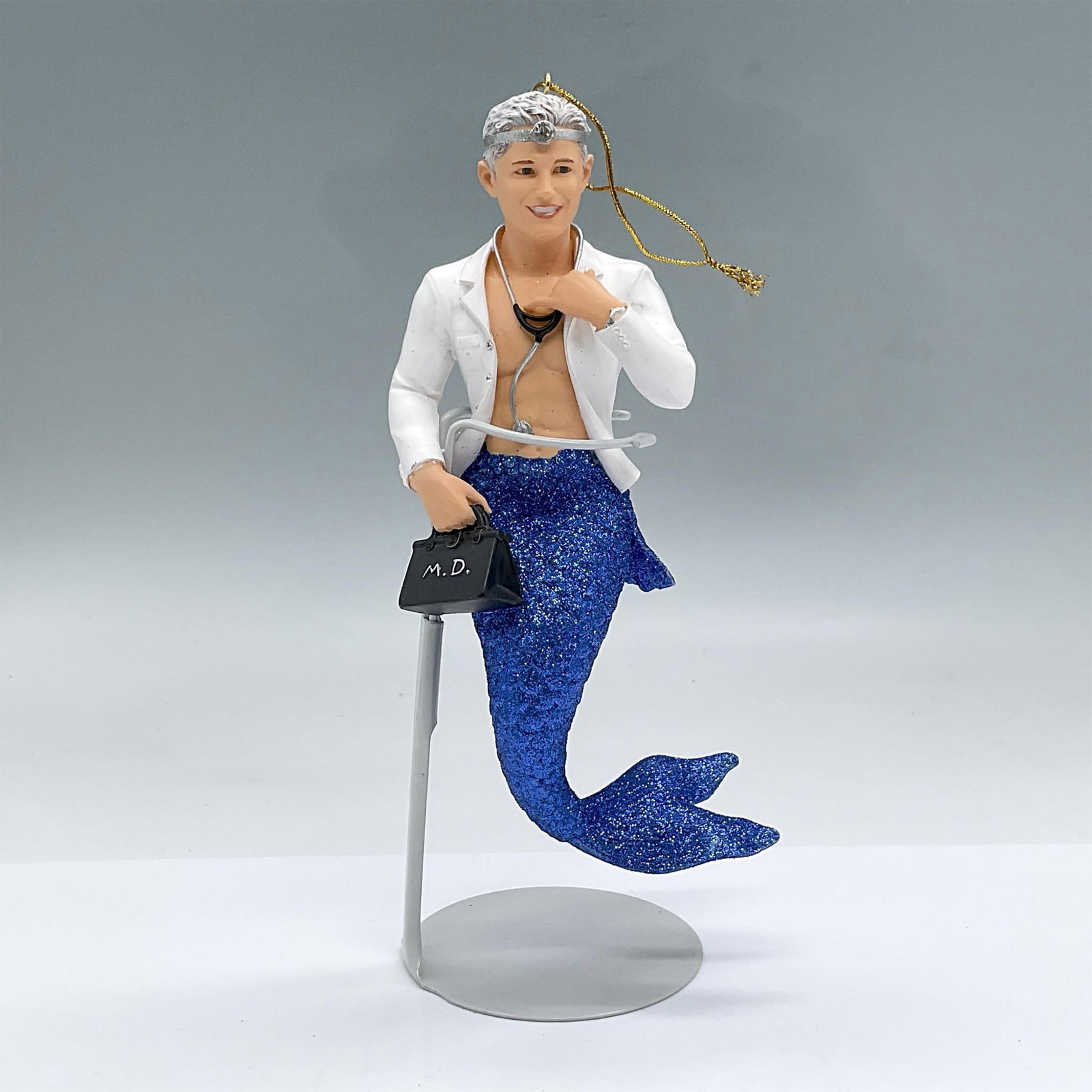 December Diamonds, Merman Collection, Dr Fish: Dr. Fish and his medical bag are part of the Merman Collection. He has a white doctor's coat and blue sparkly fish tail. This item has its original box. Box measures: 3.25"L x 4.25"W x 8.75"H. Issued: