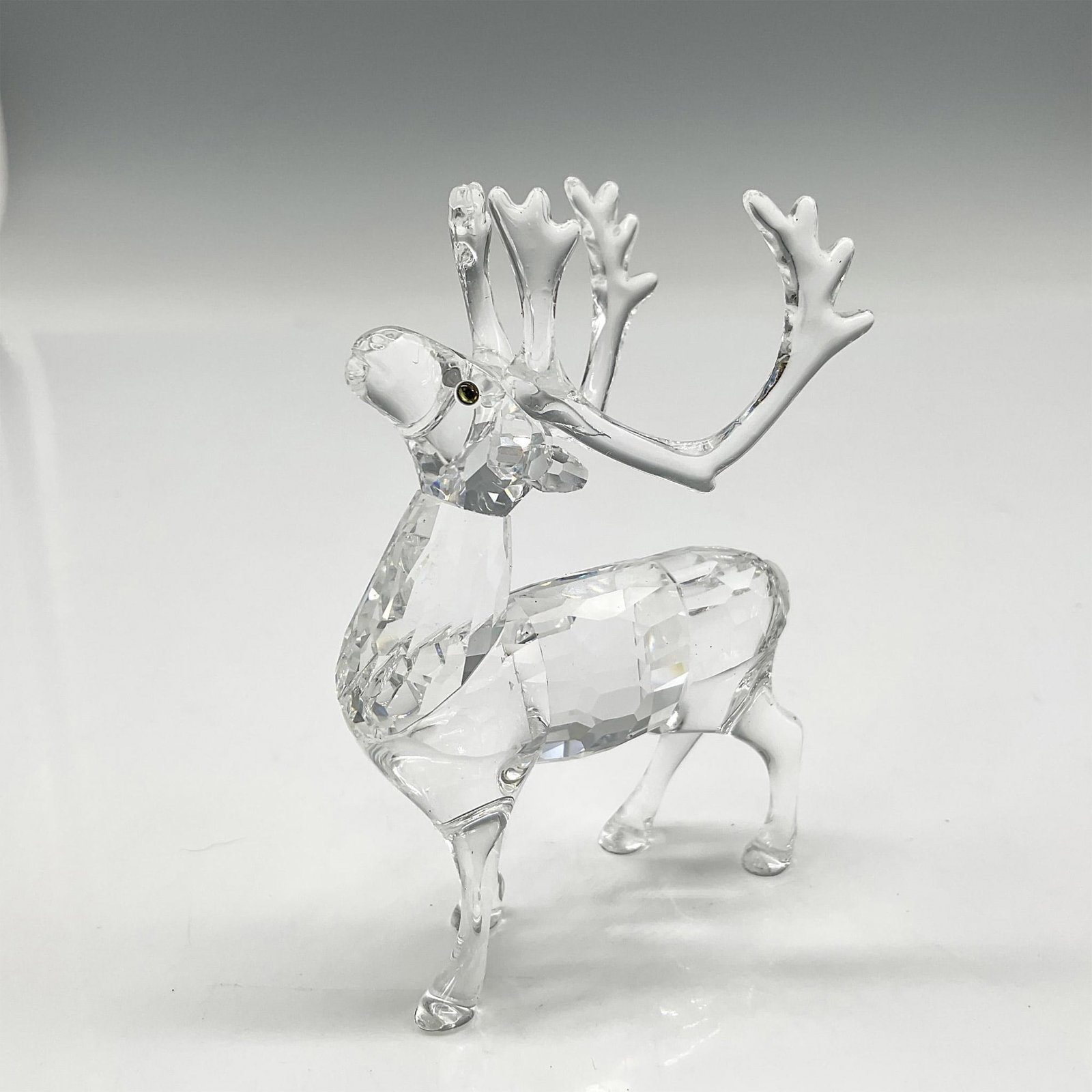 Swarovski Silver Crystal Figurine, Reindeer: Part of the Exquisite Accents group this crystal figurine has a faceted body, clear smooth haunches and antlers with amber colored crystal eyes. Swarovski backstamp. 7475 000 602. This item has its or