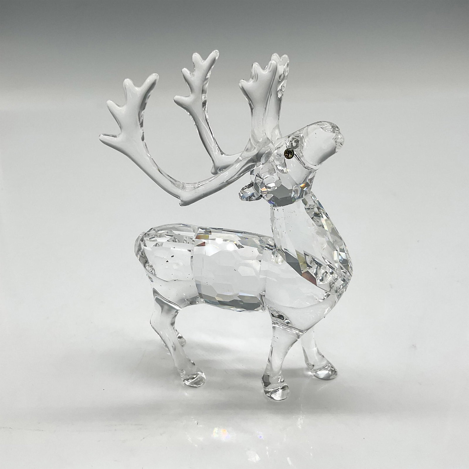 Swarovski Silver Crystal Figurine, Reindeer: Part of the Exquisite Accents group this crystal figurine has a faceted body, clear smooth haunches and antlers with amber colored crystal eyes. Swarovski backstamp. 7475 000 602. This item has its or