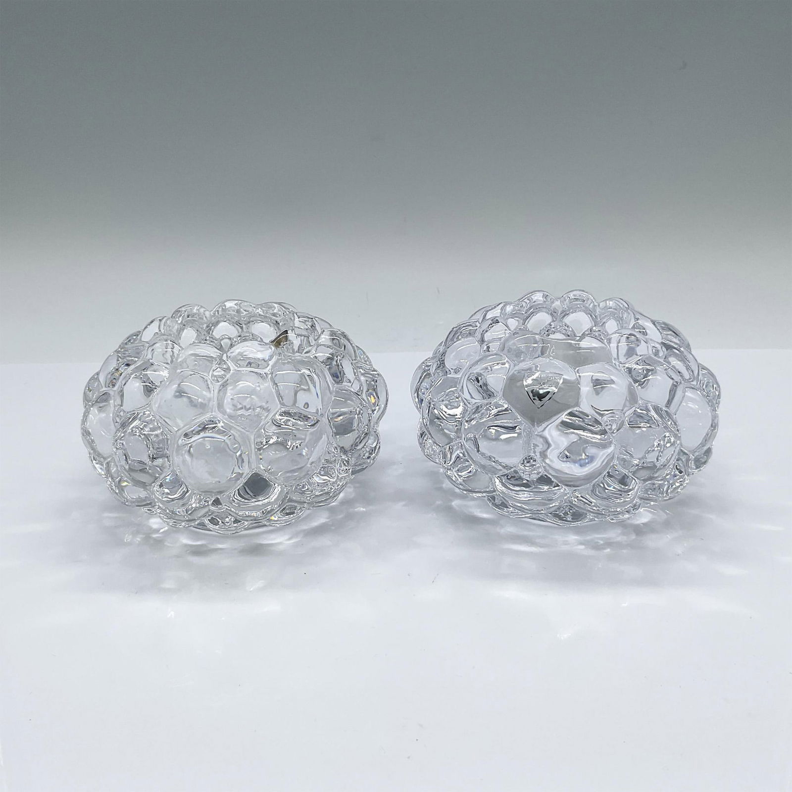 Pair of Orrefors Crystal Candle holders, Raspberry: A set of 2 clear votive candle holders in a bubble fruit form. Orrefors marked. This item has its original box: 4.75"L x 4.75"W x 3"H. Artist: Anne Nilsson Issued: Late 20th century Dimensions: 4.25"W