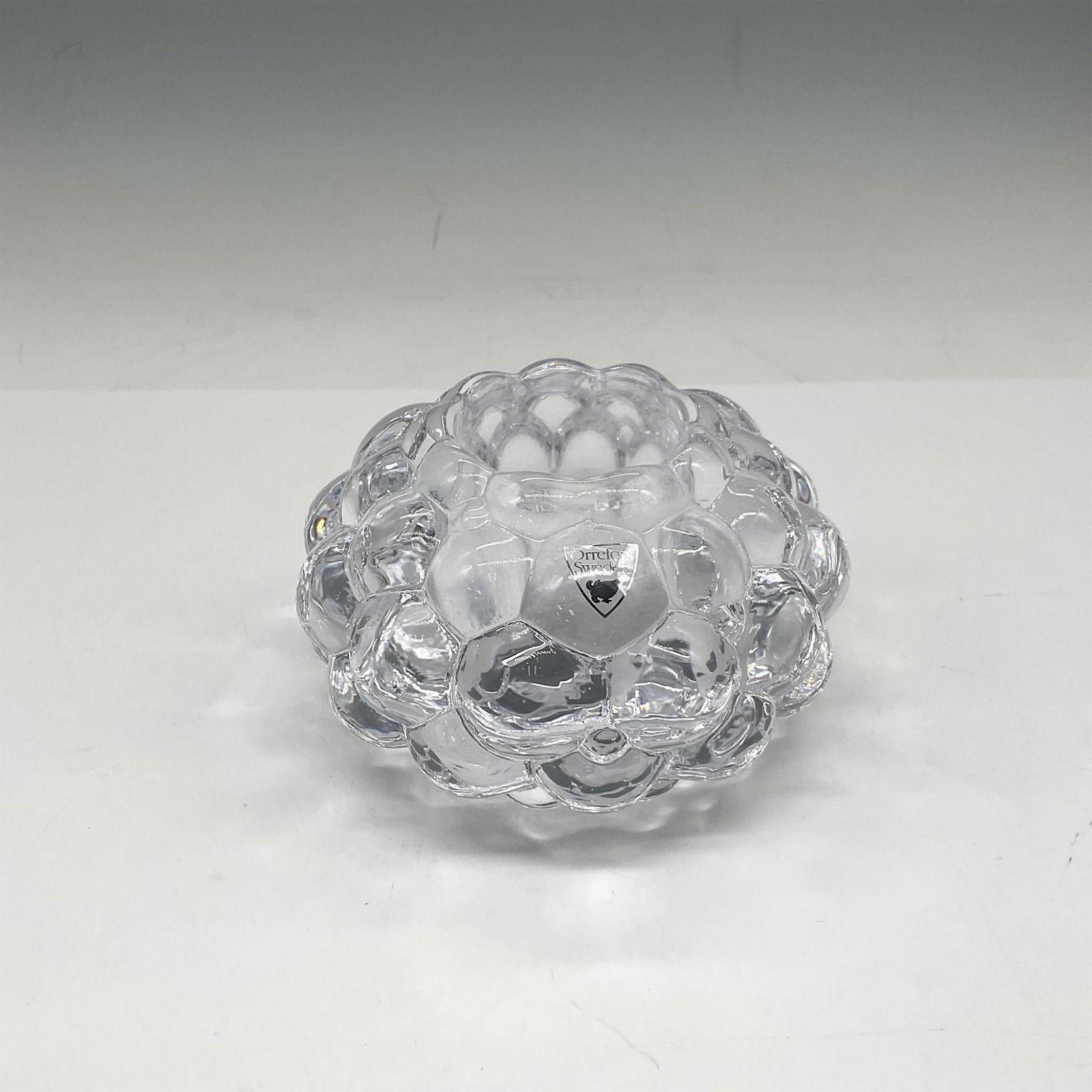 Orrefors Crystal Candle Holder, Raspberry: Bubble crystal design with smooth center at holder. Orrefors mark. This item has its original box: 4.5"L x 4.5"W x 3"H. Artist: Anne Nilsson Issued: 21st century Dimensions: 3"H x 4.25" dia. Manufactu