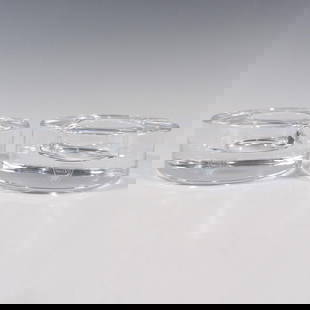 Pair of Orrefors by Lena Bergstrom Candle Holder, Puck: A set of 2 clear crystal votive cylindrical candle holder. Orrefors stickered. One candle holder has its original box: 4.5"L x 4.5"W x 2.25"H. Artist: Lena Bergstrom Dimensions: 3.75"W x 1.5"H Manufac