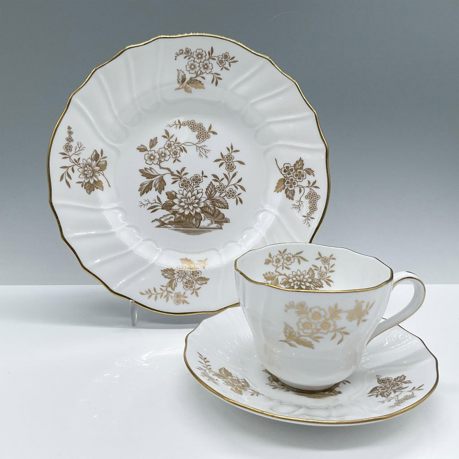 Spode Copeland Bone China Tea Trio: Features gold flower arrangements and rims. Spode backstamp. Issued: 20th century Dimensions: Cup: 4.5''L x 3.5''W x 2.75''H; Dessert plate: 1''H x 8''dia Manufacturer: Spode Country of Origin: Englan