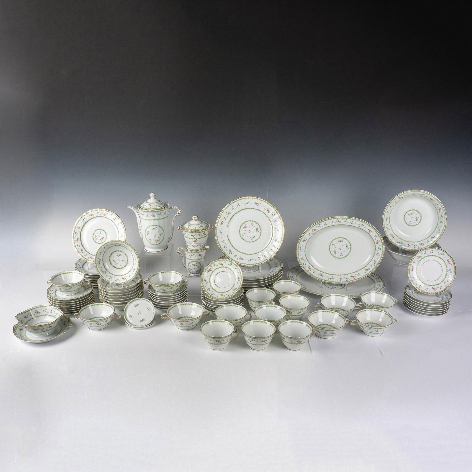 83pc Bernardaud China, Artois Vert - Versailles Shape: White porcelain decorated in a polychrome flowers and green laurel wreath pattern. Includes 8 teacups (4.5"L x 4"W x 2.5"H), 8 teacup saucers (5.75"W x 0.75"H), 8 double-handled soup bowls (6.25"L x 4