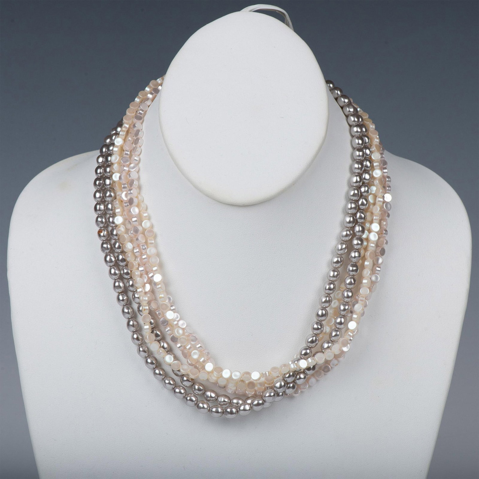 Monet Six-Strand Two-Tone Faux Pearl Necklace: Four strands of flat round white pearlescent beads with two strands of faux silver pearls. Dimensions: 18"L Manufacturer: Monet Jewelry Country of Origin: United States