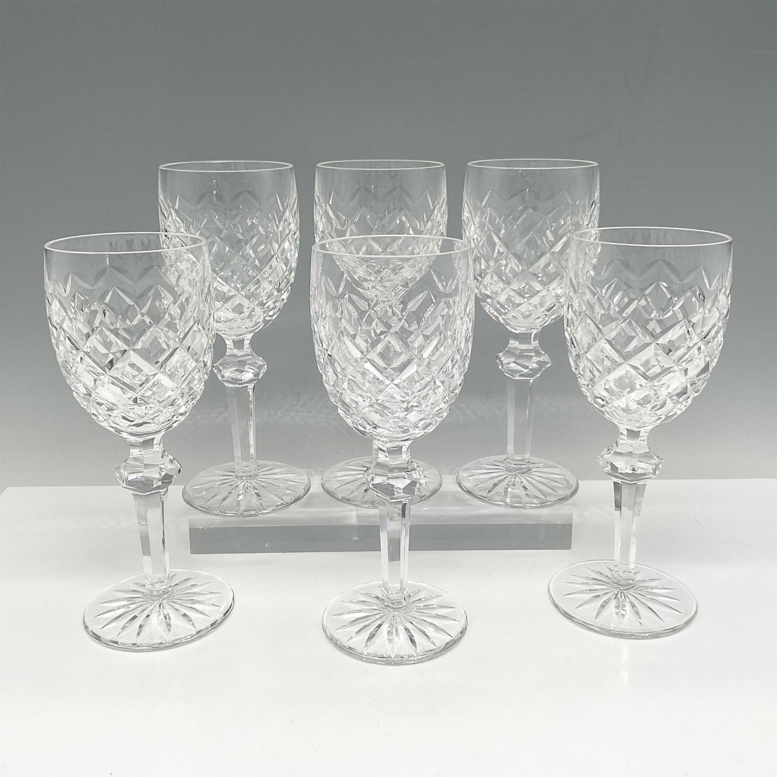 6pc Waterford Crystal Powerscourt Claret Wine Glasses: Beautiful clear-cut crystal with crisscross design and long stem with designed knob at base of bowl. Waterford acid mark. Issued: 20th century Dimensions: 6.5"H x 2.75" dia. Manufacturer: Waterford Co