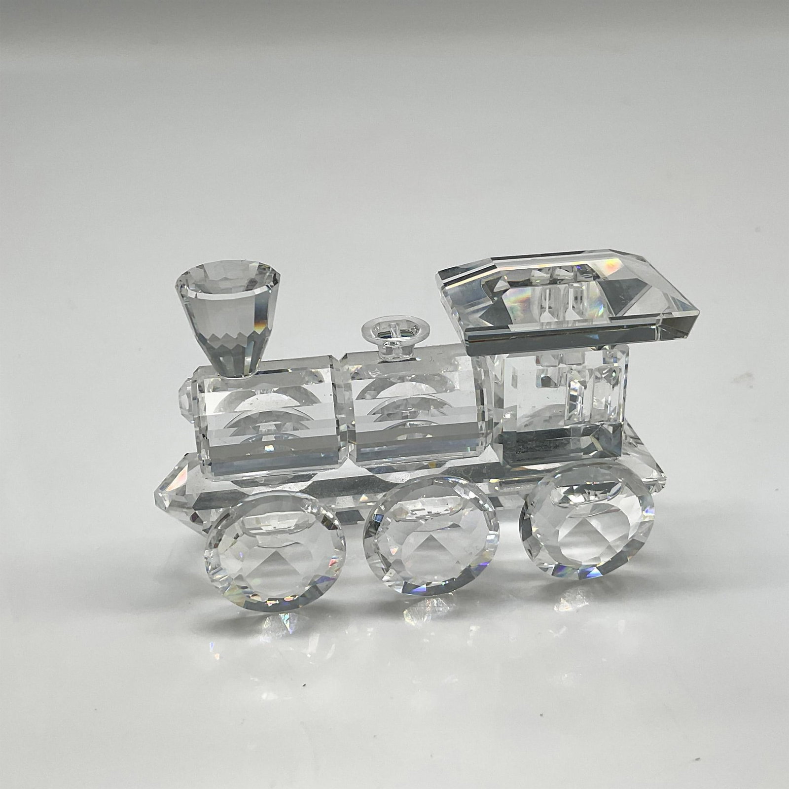 Swarovski Silver Crystal Figurine, Locomotive: First piece of the 6-piece Silver Crystal Express, with its faceted design it gleams when it catches the light. Swarovski backstamp. 7471 000 001. This item has its original box: 4"H x 3.25" dia. Arti