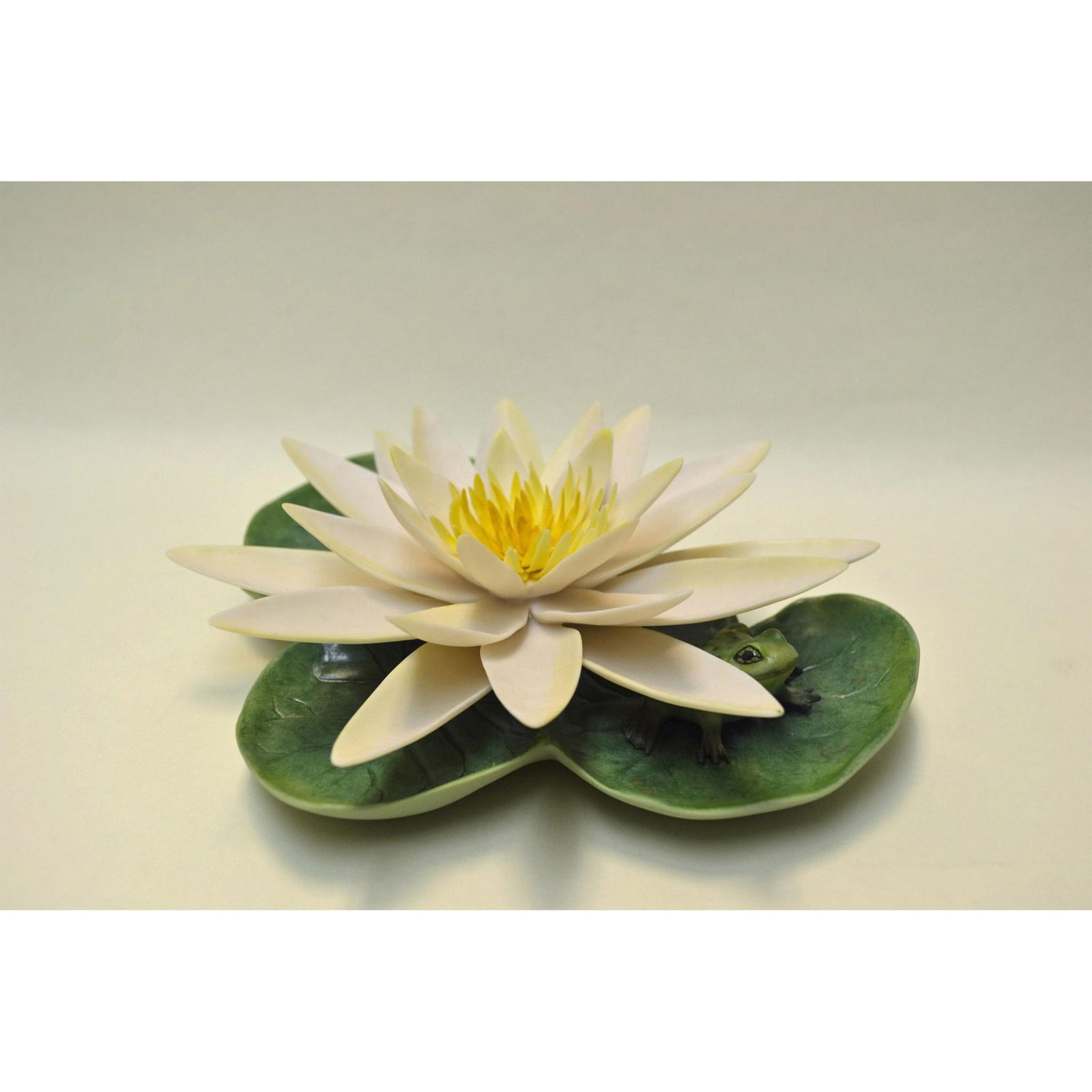 Cybis Porcelain Water Lily W/Frog Sculpture: Bisque Porcelain Decorated, hand created, hand painted by the Artisans of the Cybis Studios. Featuring a Frog sitting on a Lily Pad under a Beautiful White Water Lily. Hallmark: 20554. Introduced in 1