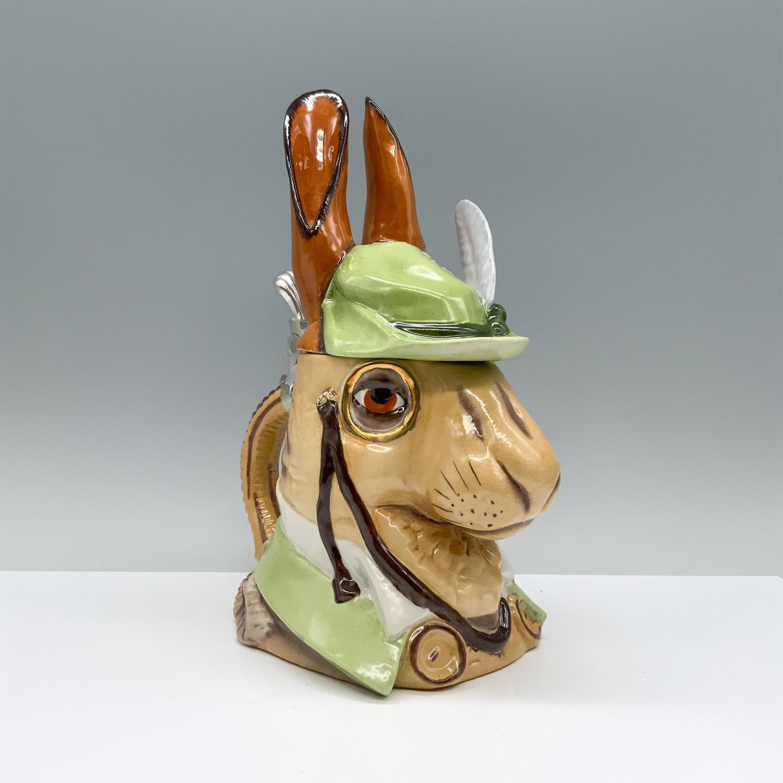 Domex Gentleman Rabbit Beer Stein: This festive stein features a brown rabbit donning a green jacket, a feathered hat, and a monocle. Domex manufacturing sticker. Dimensions: 7.5"L x 4.5"W x 9.75"H Manufacturer: Domex Country of Origin