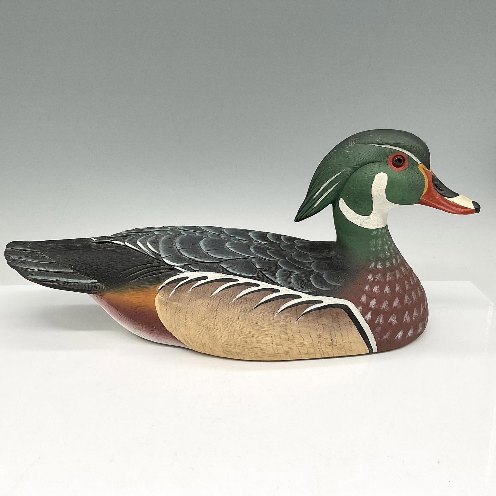 Briley Co. Wood Duck Drake 14": Colorful, hand painted decoy colored in green, burnt red, black and cream with accents of orange. Briley Co. sticker. Issued: 20th century Dimensions: 14"L x 5.5"W x 6.5"H Manufacturer: Briley Co. Cou