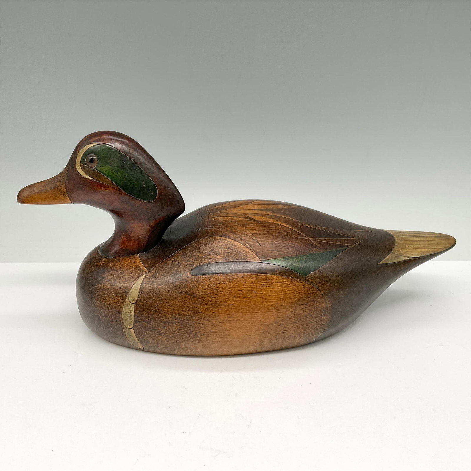 John Jeffrey Barto Wood Waterfowl Decoy, Green Winged Teal: Hand carved and hand painted in natural wood tones with distinct green marks on head and accented on back feathers. Signed and dated by artist. Artist: John Jeffrey Barto Issued: 1985 Dimensions: 11"L
