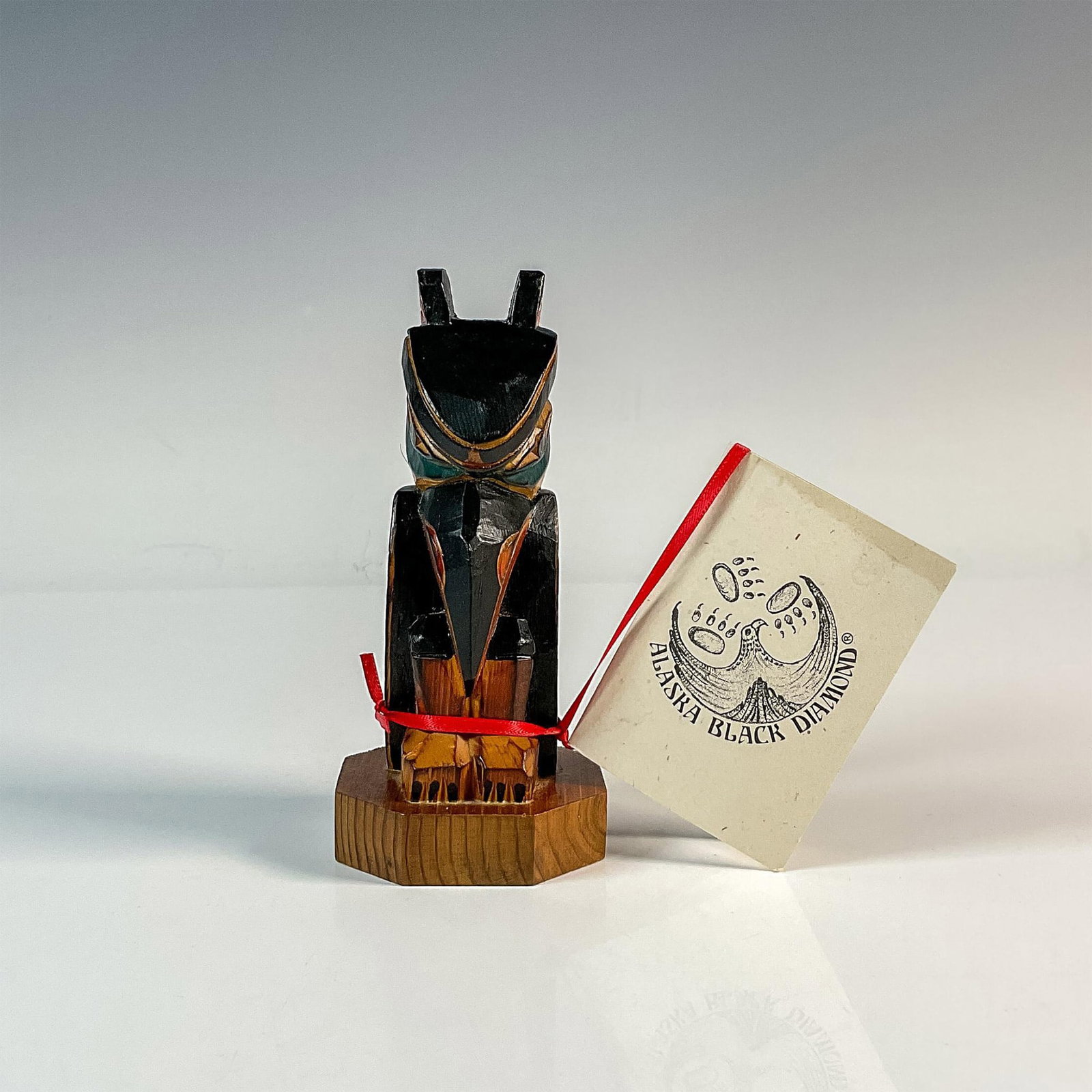 Alaska Black Diamond Wood Bird Totem: Hand carved yellow cedar bird totem in black, green and red coloration. Made in Ketchikan, Alaska. Dimensions: 5.25"L x 5.25"W x 5"H Country of Origin: United States