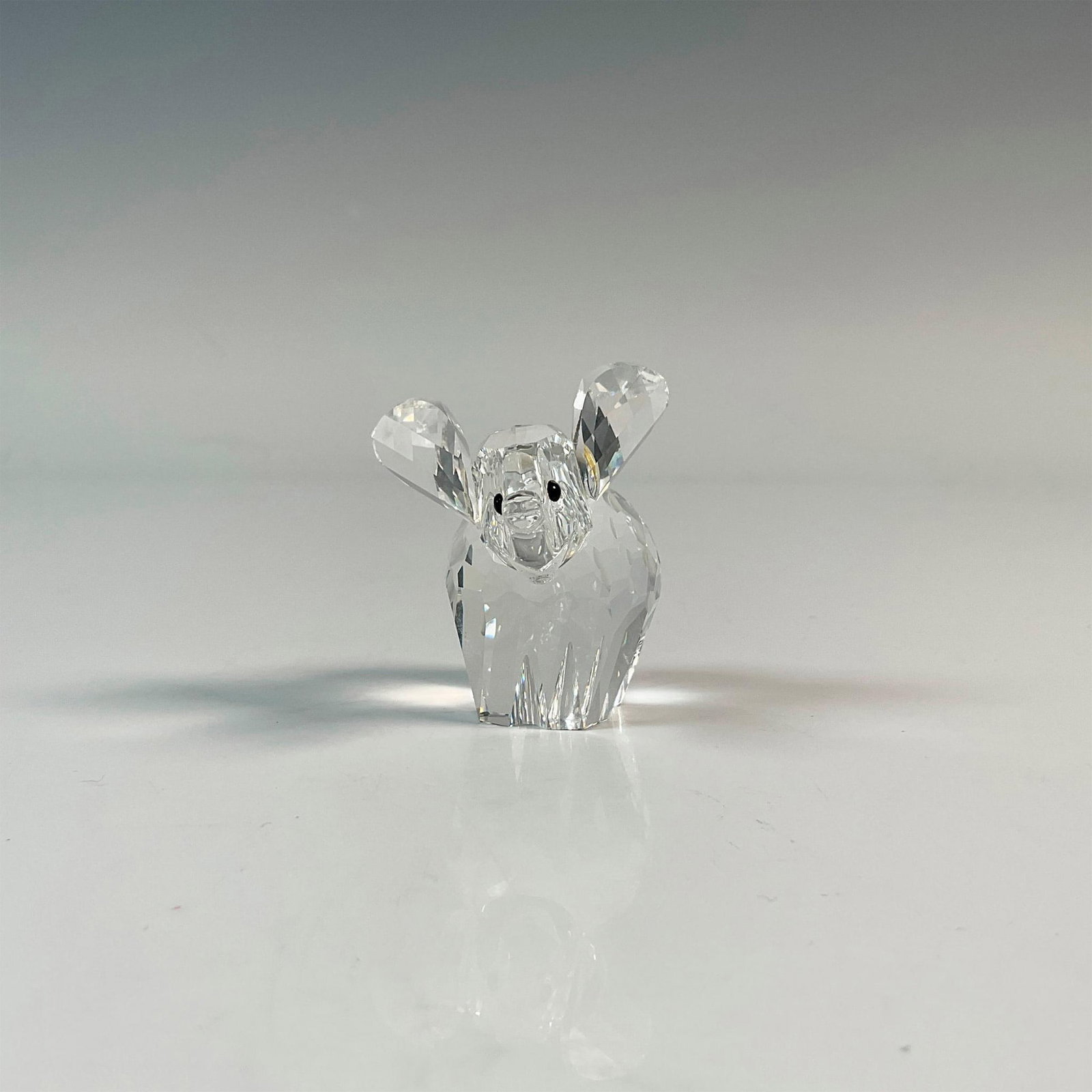 Swarovski Crystal Figurine, Elephant: Adorable clear facetted crystal with black eyes and frosted tail. Part of the African Wildlife collection. Swarovski backstamp. Includes the original box, dimensions: 5''H x 3.25''dia. Artist: Adi Sto