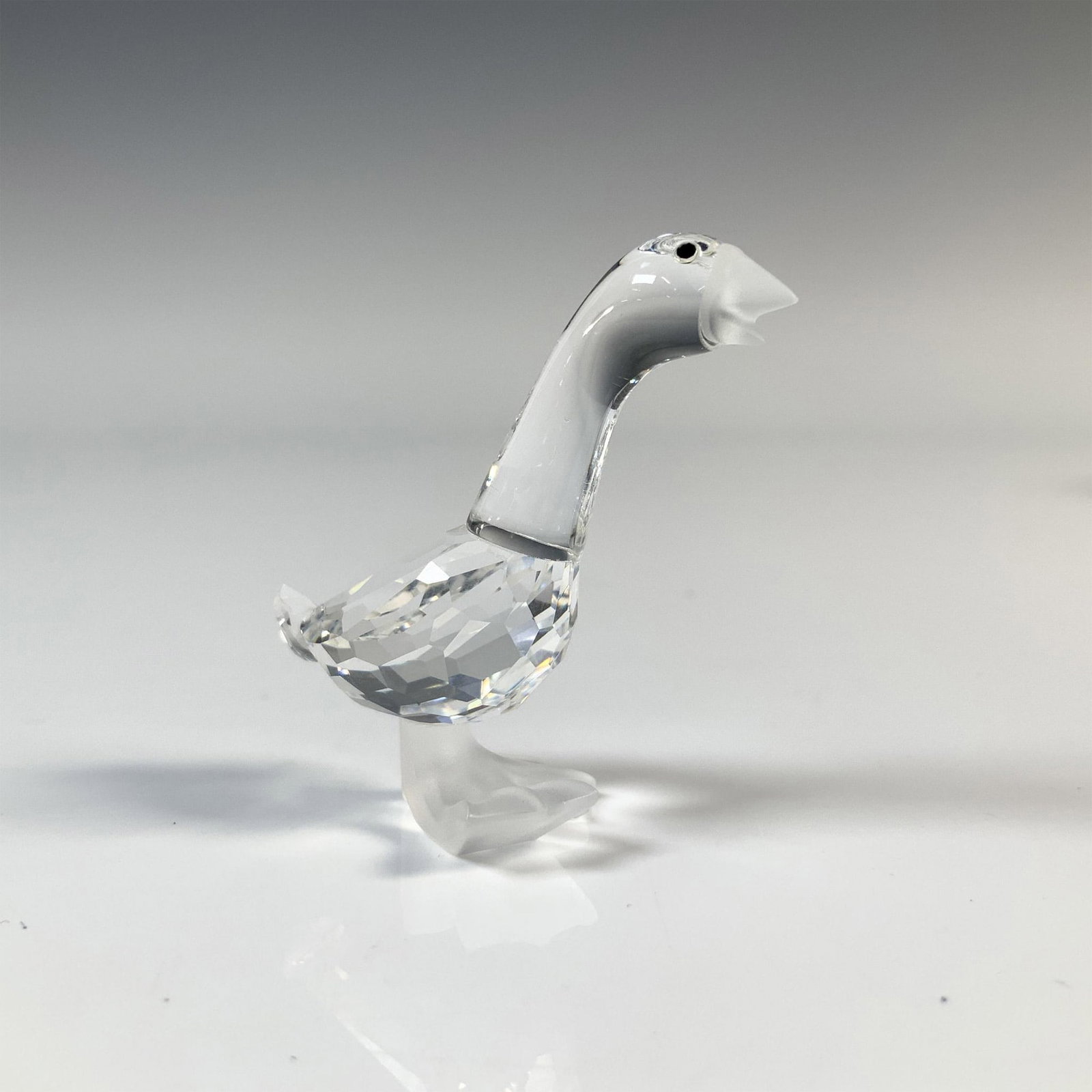 Swarovski Silver Crystal Goose Figurine, 7613 000 002: Goose has a clear cut crystal body, frosted bill and feet and black eyes. This item has its original box which measures 2.5"H x 3.25" dia. Acid etched Swarovski backstamp. Issued: 20th Century Dimensi