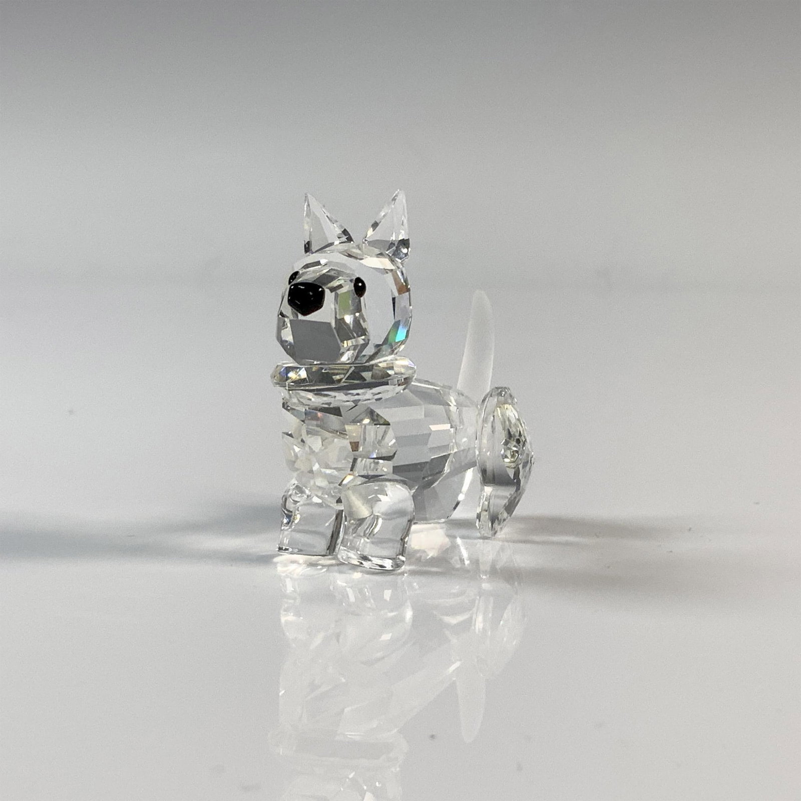 Swarovski Silver Crystal Scotty Dog Figurine, 7619 000 0002: Scottish Terrier has a clear cut crystal body with black eyes and nose. This item has its original box which measures 3.75"H x 3.25" dia. Acid etched Swarovski backstamp. Issued: 20th Century Dimensio