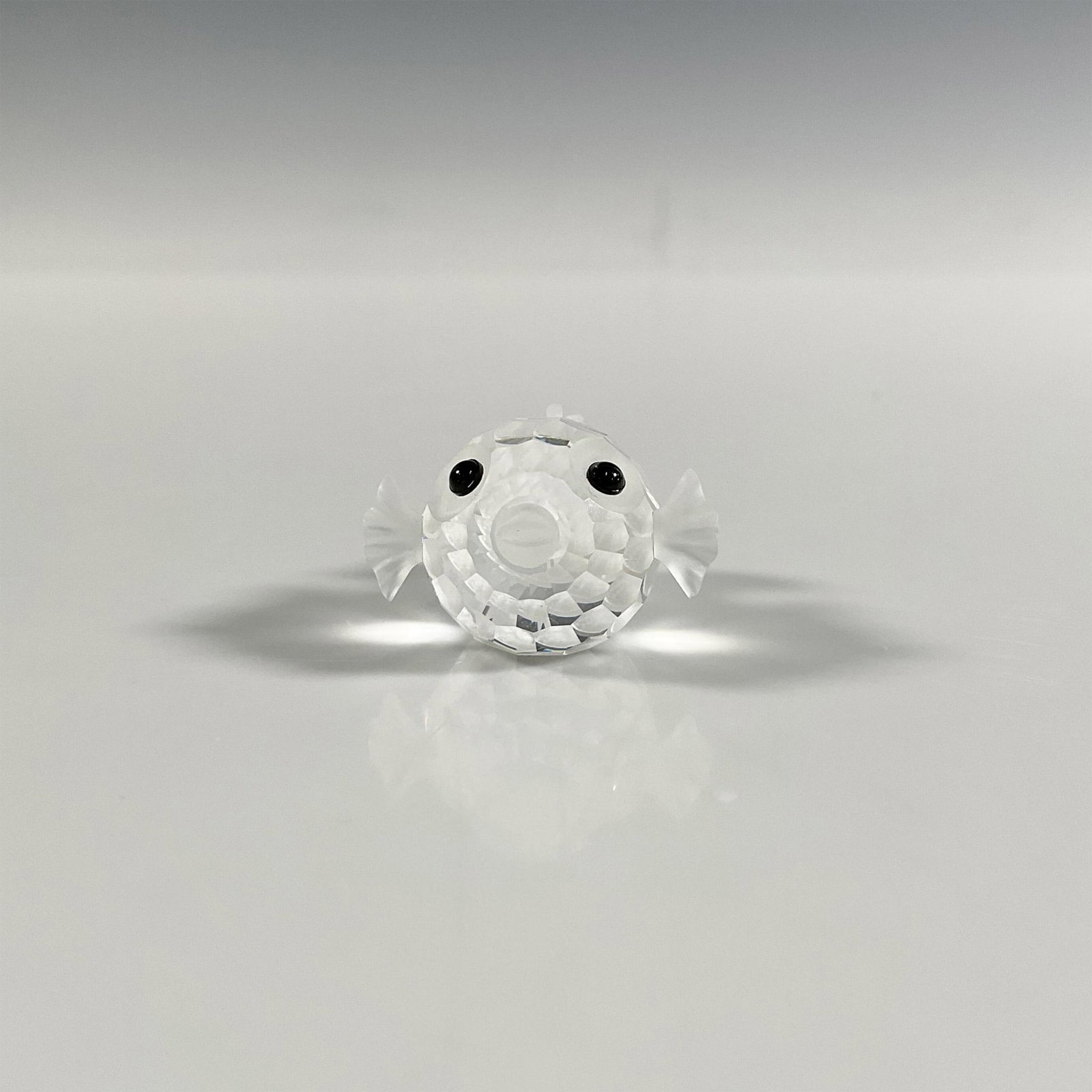 Swarovski Silver Crystal Blowfish Figurine: A clear and frosted faceted figure of a puffer fish with black eyes. Swarovski marking. This item has its original box: 2.5"W x 2.75"H. Dimensions: 1.5"L x 1.25"W x 0.75"H Manufacturer: Swarovski Coun