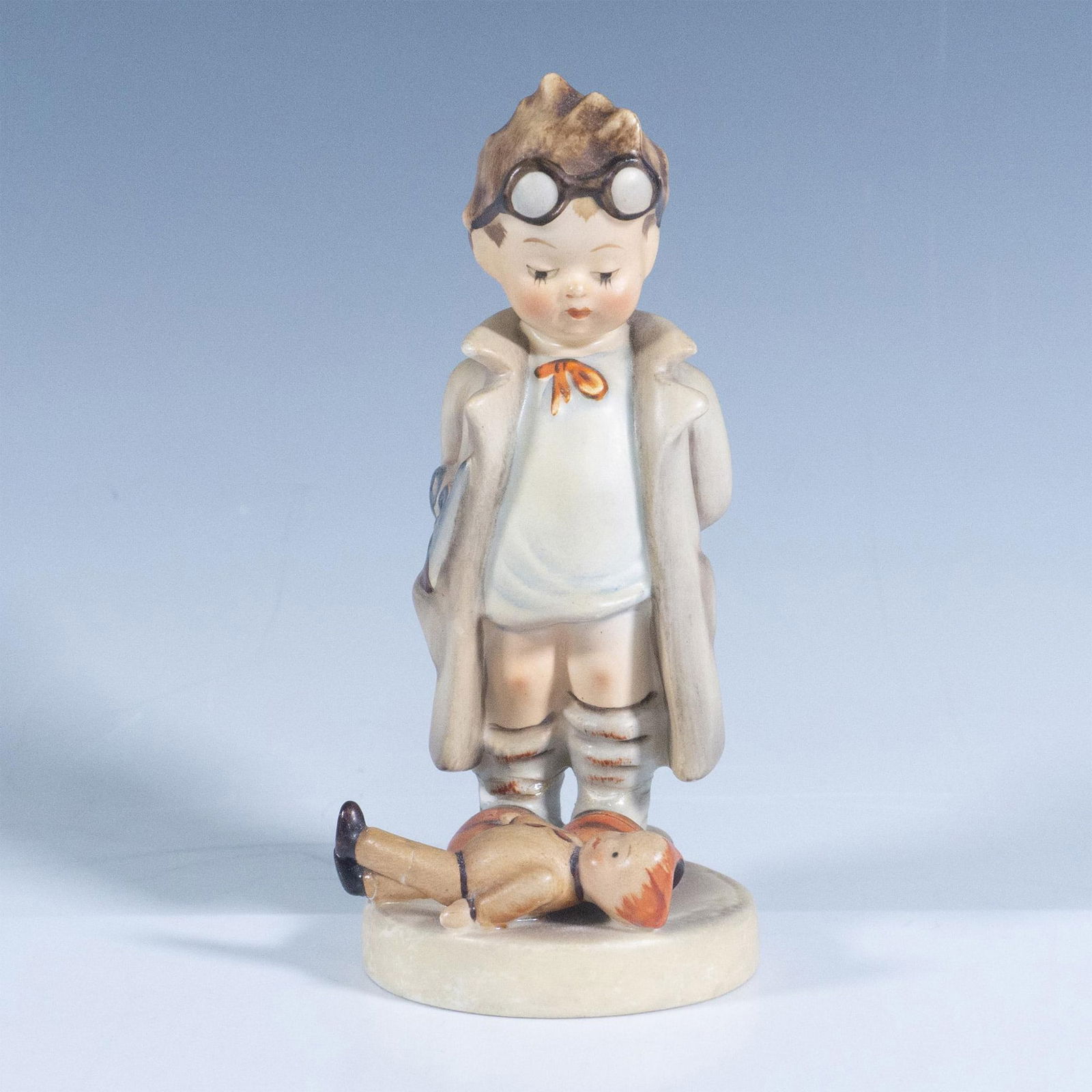 Goebel Hummel Figurine, Doctor: Features a little boy in a doctor coat examining a doll. Goebel backstamp. Artist: M. I. Hummel Issued: 20th century Dimensions: 5.5''H x 2.25''dia Manufacturer: Goebel Hummel Country of Origin: Germ