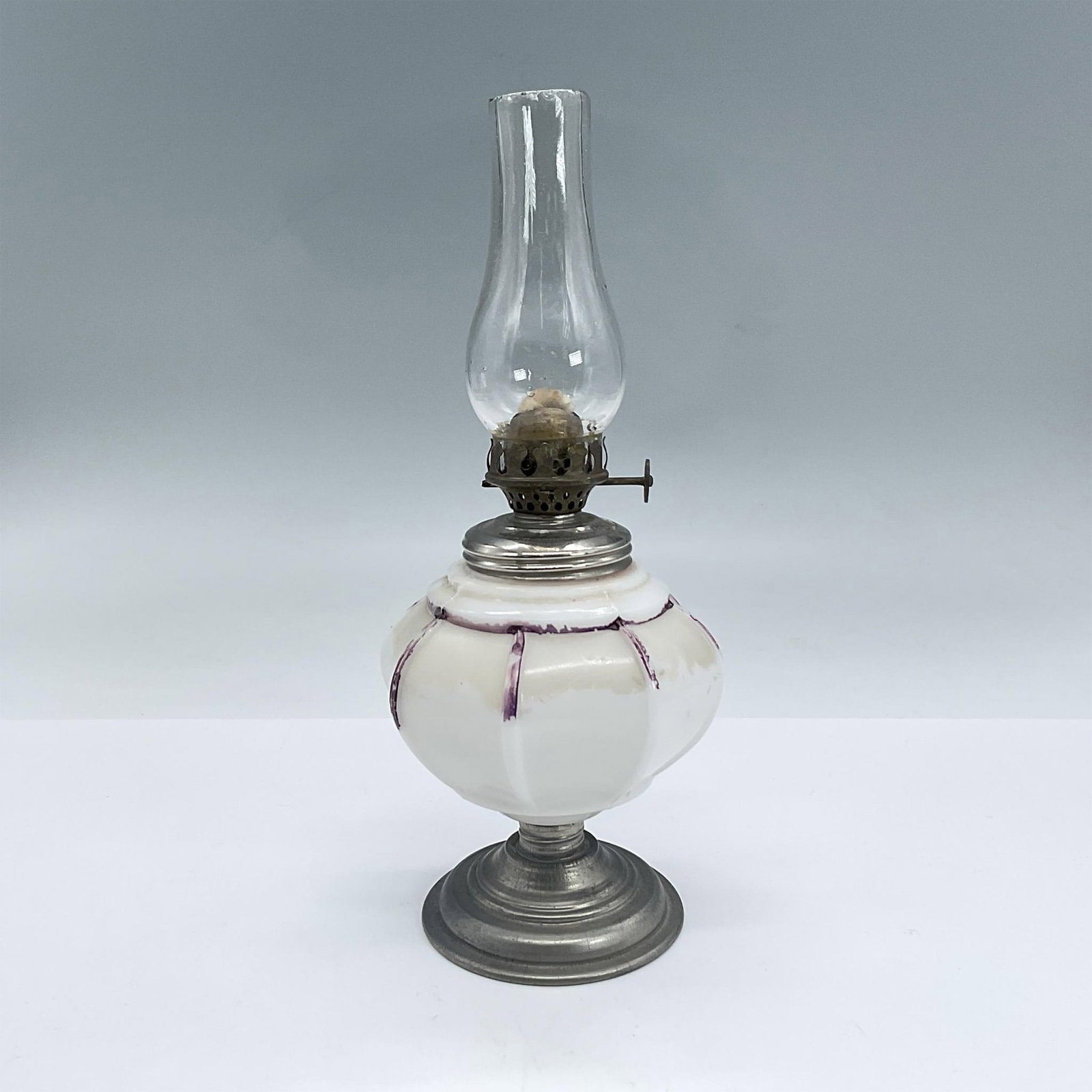 Vintage Milk Glass and Metal Oil Lamp: Oil lamp with clear glass chimney, white milk glass body, silvertone metal and bronze hardware. Dimensions: 9"H x 3.5" dia