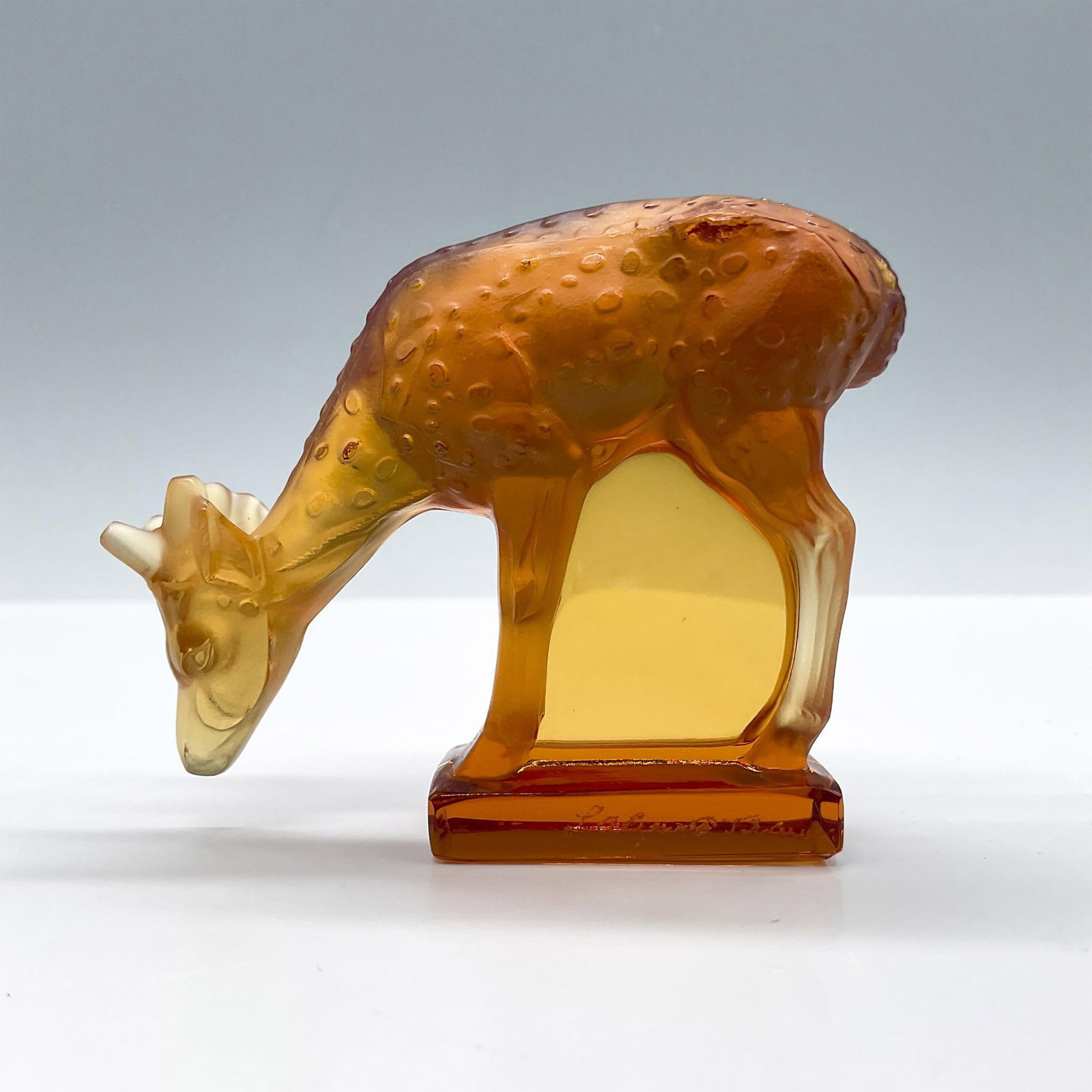 Lalique Crystal Figurine, Amber Deer: Frosted amber crystal depicting a deer leaning forward. Lalique engraved signature on side. Issued: 20th century Dimensions: 3''L x 1''W x 2.75''H Manufacturer: Lalique Country of Origin: France