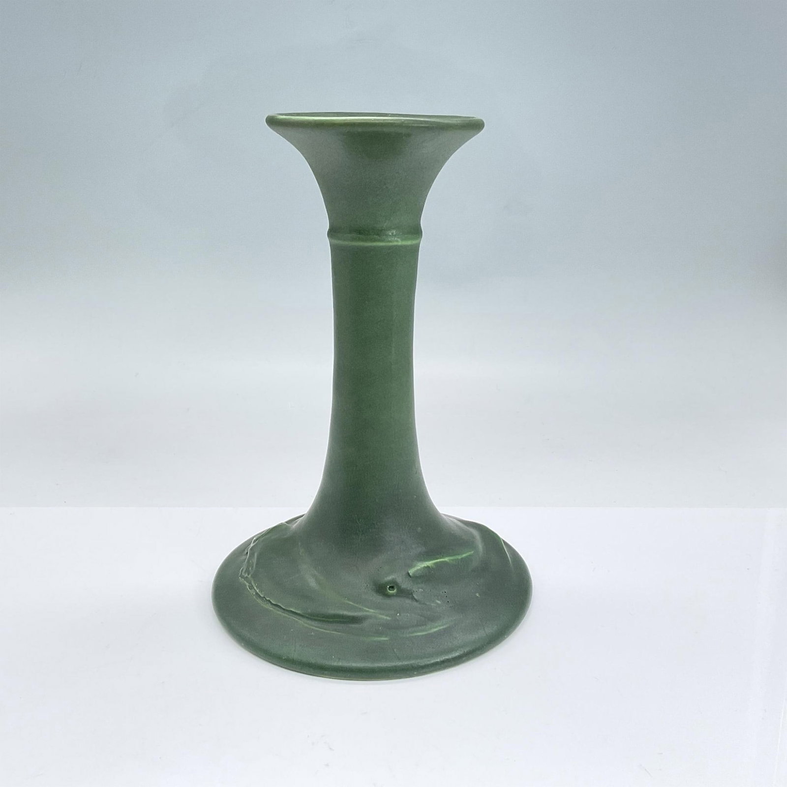 Rookwood Pottery Candlestick, Evergreen, Fish: Dark green earthenware candlestick with two abstract fish on the base in low-relief. Rookwood Pottery backstamp. Dimensions: 8"H x 5.25" dia Manufacturer: Rookwood Country of Origin: United States