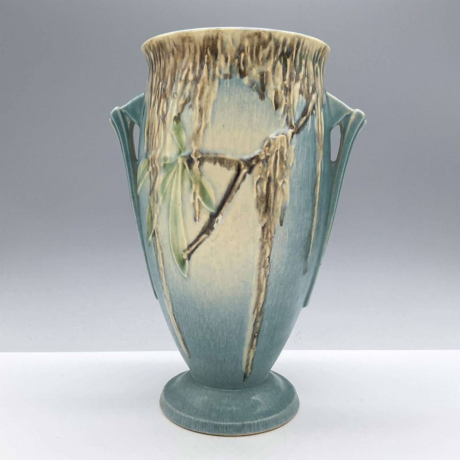 Roseville Pottery Vase, Moss 782-9: Features a turquoise background with dripping brown glaze hanging from long-leafed branches. Roseville backstamp. Issued: 20th century Dimensions: 5''L x 7''W x 9.5''H Manufacturer: Roseville Country 