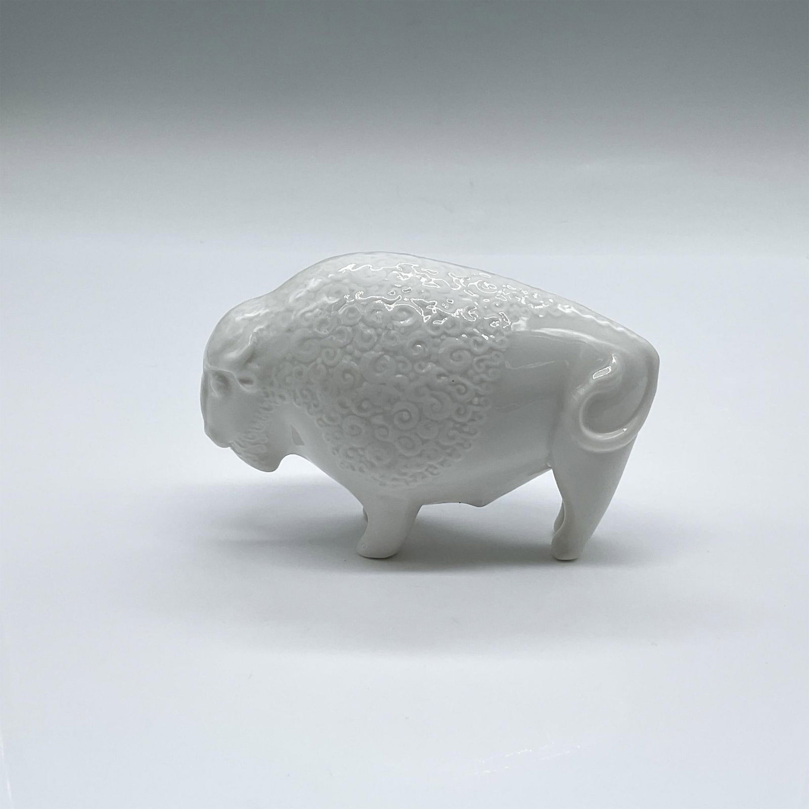 Minton All White Porcelain Animal Figurine, Bison: A small figure of an American Buffalo, detailed on the bison's coat. Minton backstamp. Issued: 1987 Dimensions: 4.25"L x 2"W x 2.75"H Manufacturer: Minton Country of Origin: England
