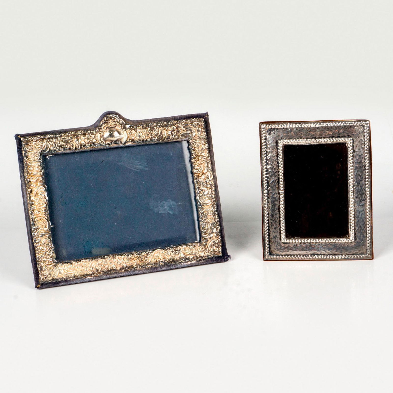 2pc Vintage Sterling Silver Picture Frames: Includes a KFL London Repousse frame lined with blue fabric and a small squared frame line with brown fabric. Hallmarked KFL and makers marks, Gnlenn 0.999. Largest measures: 7"L x 6"W. Smallest measu