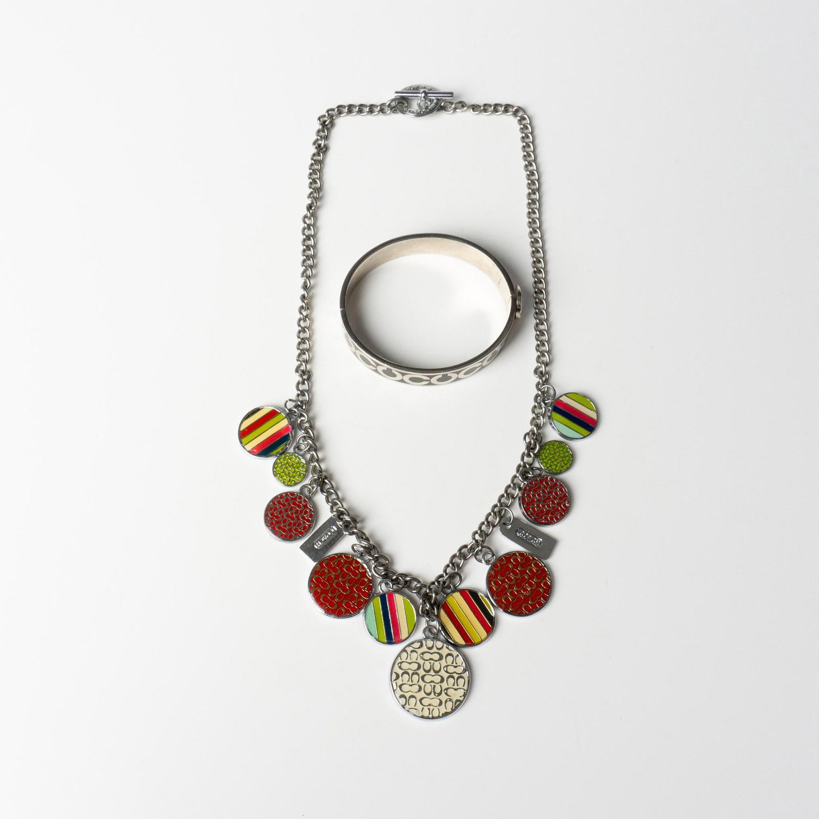 2pc Coach Retro Medallion Necklace and Bracelet: The silver metal necklace with colorful medallion charms measures 22"L. The bracelet measures approximately 7.25"L around the inside. Dimensions: See Description Manufacturer: Coach