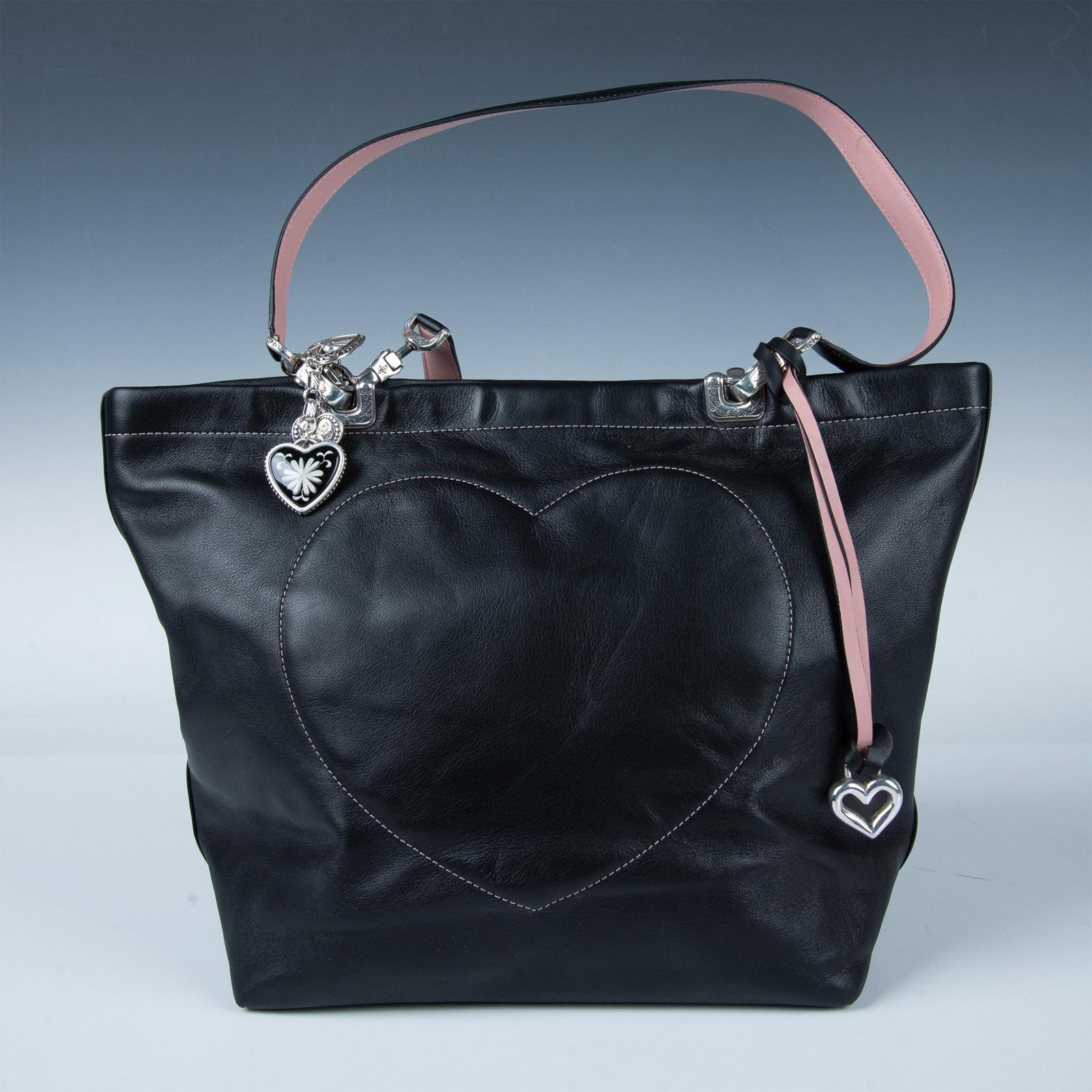 Brighton Leather Handbag: This beautiful and soft handbag features a full kid leather in black exterior with an embroidered heart. The magnetic closure opens to a fabric-lined interior with additional pockets. It has a black a