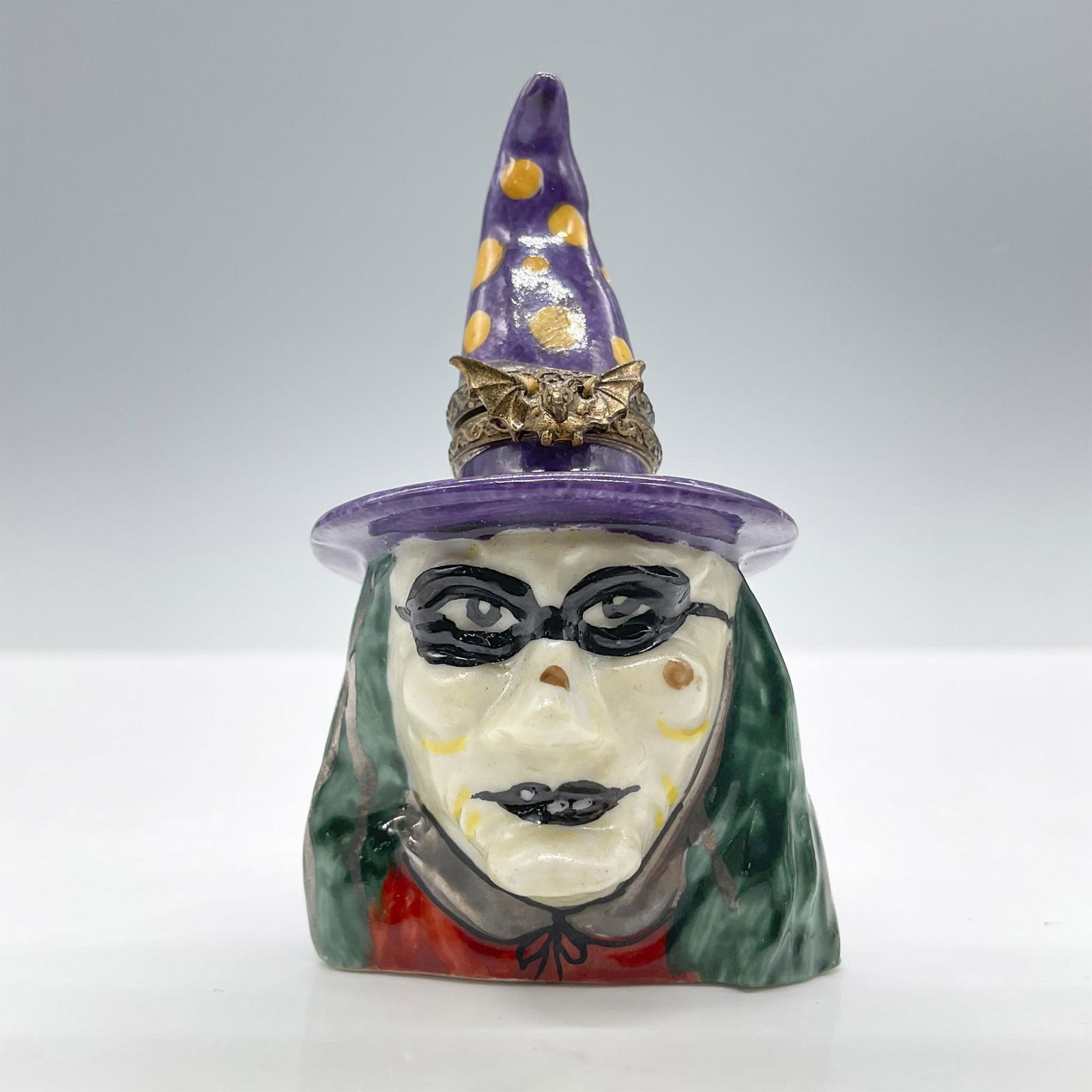 Limoges Porcelain Treasure Box, Purple Hat Witch: Hand painted in Limoges France. Depicts a witch head with green hair and a purple-yellow dotted hat. Perfect for Halloween! Signed MB Peint Main Limoges France. Issued: 20th century Dimensions: 1.5''L