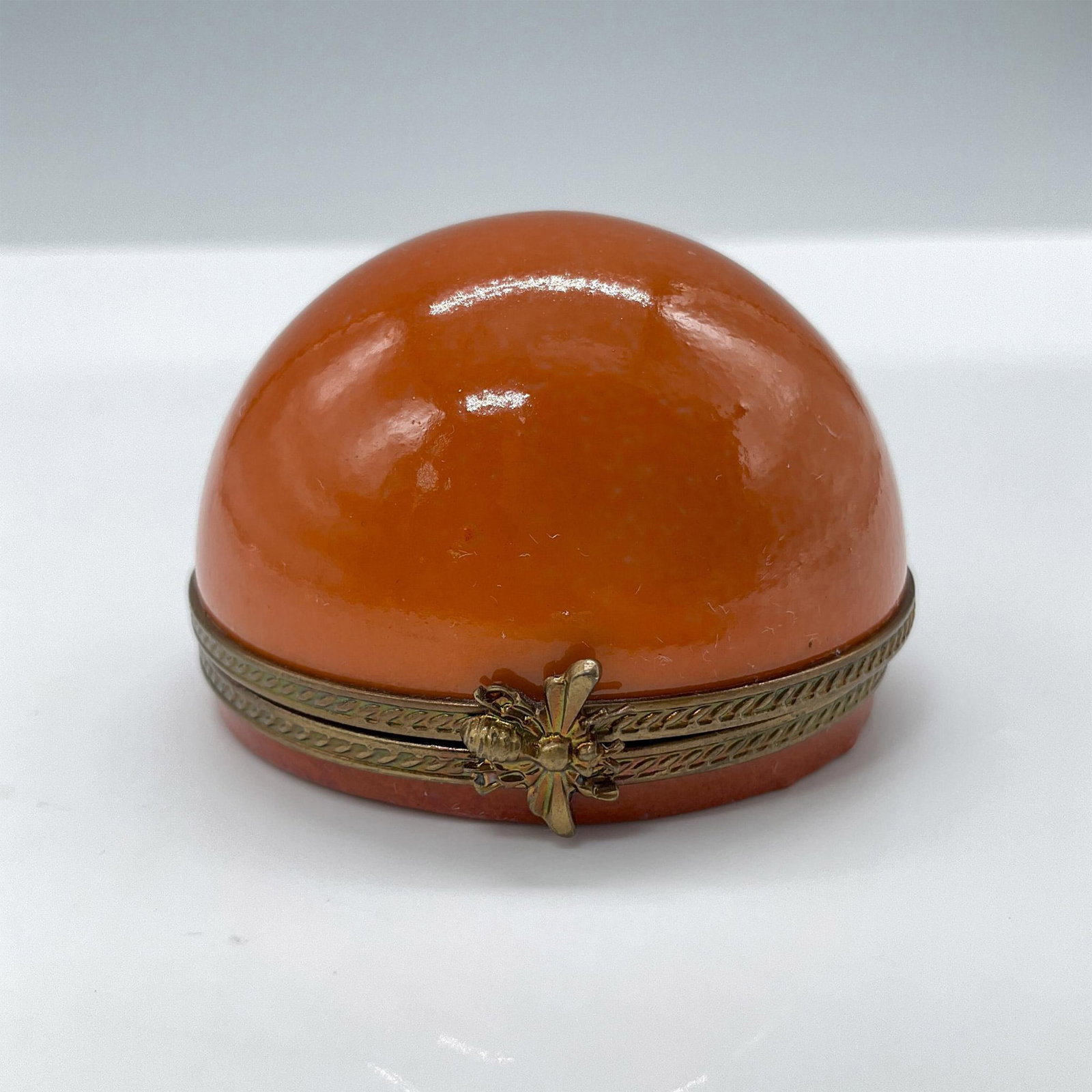 Limoges Porcelain Treasure Box, Orange: Hand painted in Limoges France. Limited edition. Features a half orange shape, decorated with a metal closure. Signed Peint Main Limoges France MB gg 9/50. Issued: 20th century Dimensions: 1.5''H x 2'