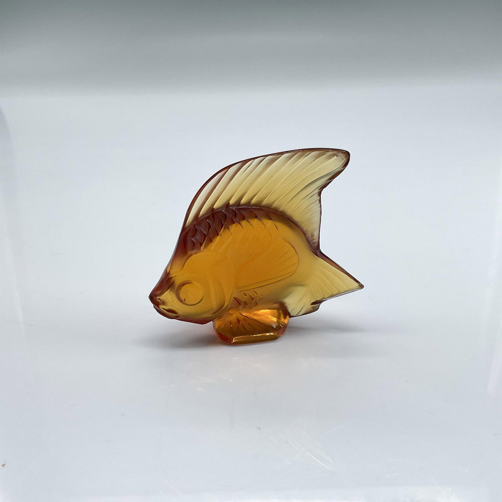 Lalique Satin Crystal Figurine, Fish, Amber: Detailed figure of a fish in satin and clear amber glass. Lalique France etched mark. Dimensions: 2"L x 0.75"W x 1.75"H Manufacturer: Lalique Country of Origin: France