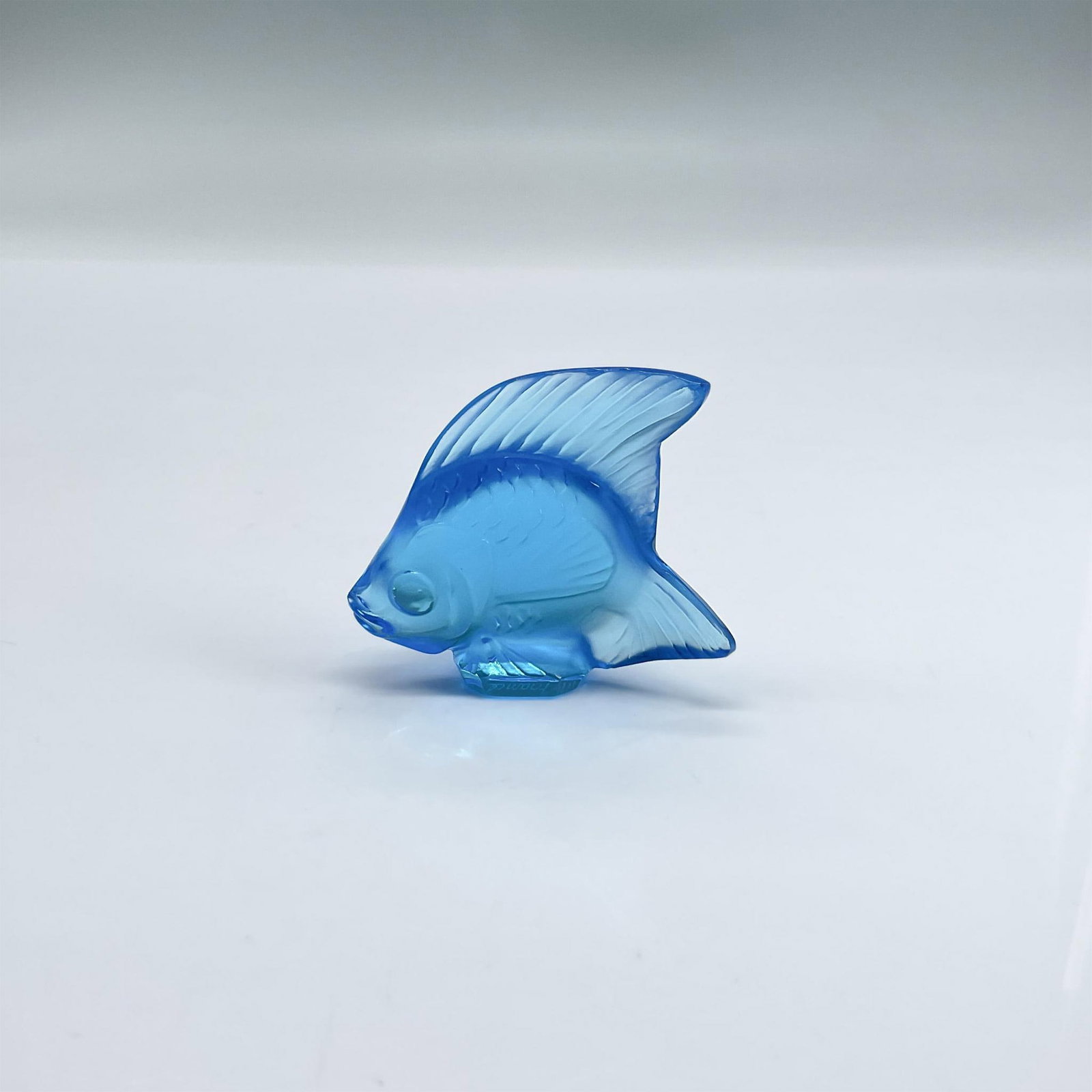 Lalique Satin Crystal Figurine, Fish, Azure Blue: Figure of a fish in satin and clear bright blue glass. Lalique France etched mark. Dimensions: 2"L x 0.75"W x 1.75"H Manufacturer: Lalique Country of Origin: France