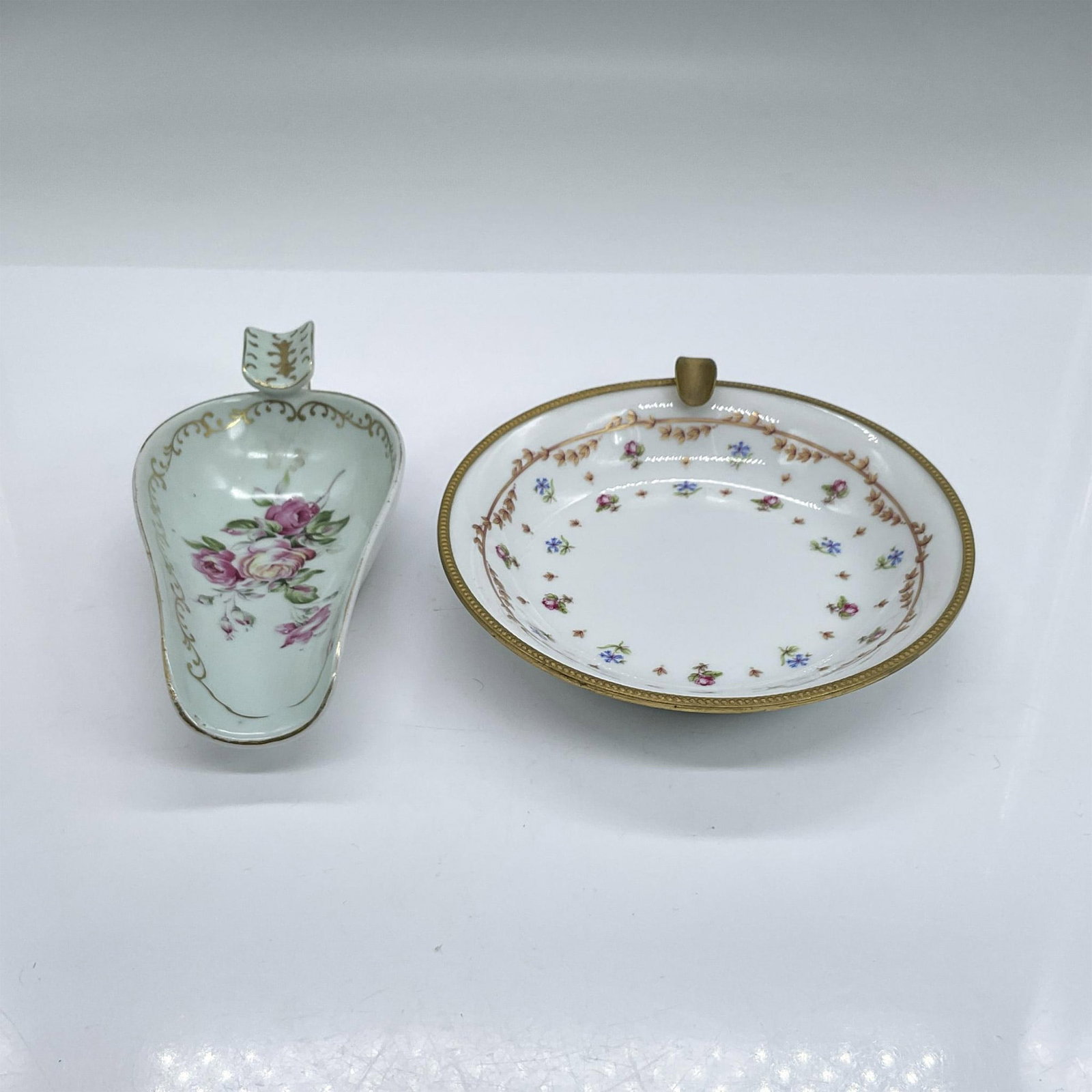2pc Vintage Limoges Ashtrays, Flowers: Two porcelain ashtrays decorated with hand-painted flowers, gold rims and accents. The larger round one with a Haviland & Co. backstamp is 1.25"H x 5.5" dia. Dimensions: See Description Manufacturer: 