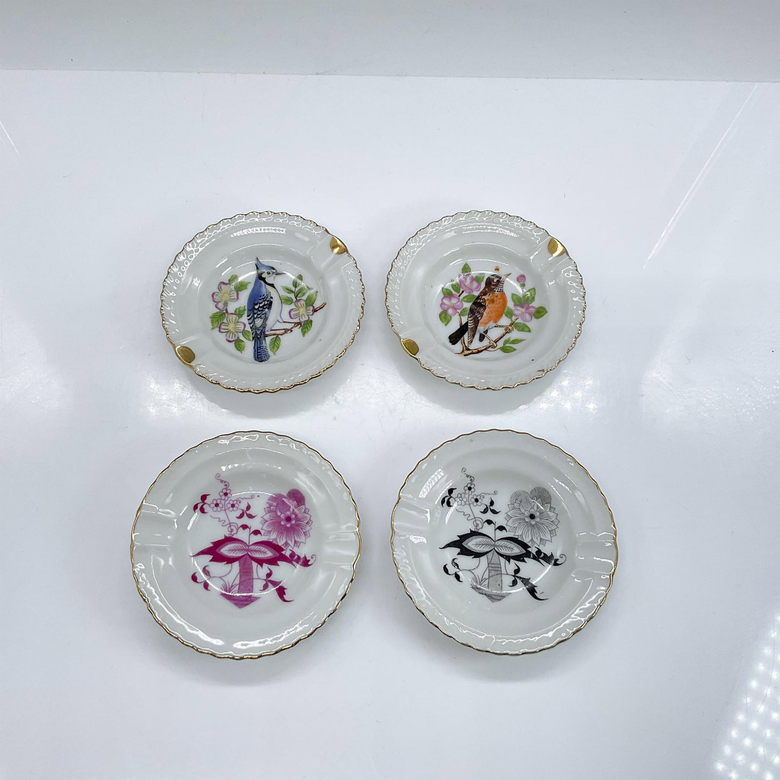 4pc Vintage Japanese Porcelain Ashtrays, Birds and Flowers: Four small ashtrays, two with images of birds and two with flowers. Dimensions: 0.5"H x 3.5" dia Country of Origin: Japan