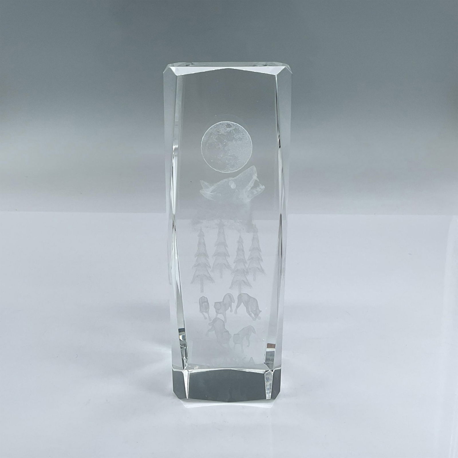 Glass Laser Etched Paperweight, Alaska 3D Wolves: Glass pillar with laser etched images of wolves, the moon, trees and the word Alaska at the bottom. Includes original box 7"L x 3"W x 2.5"H. Dimensions: 2"L x 2"W x 5.75"H