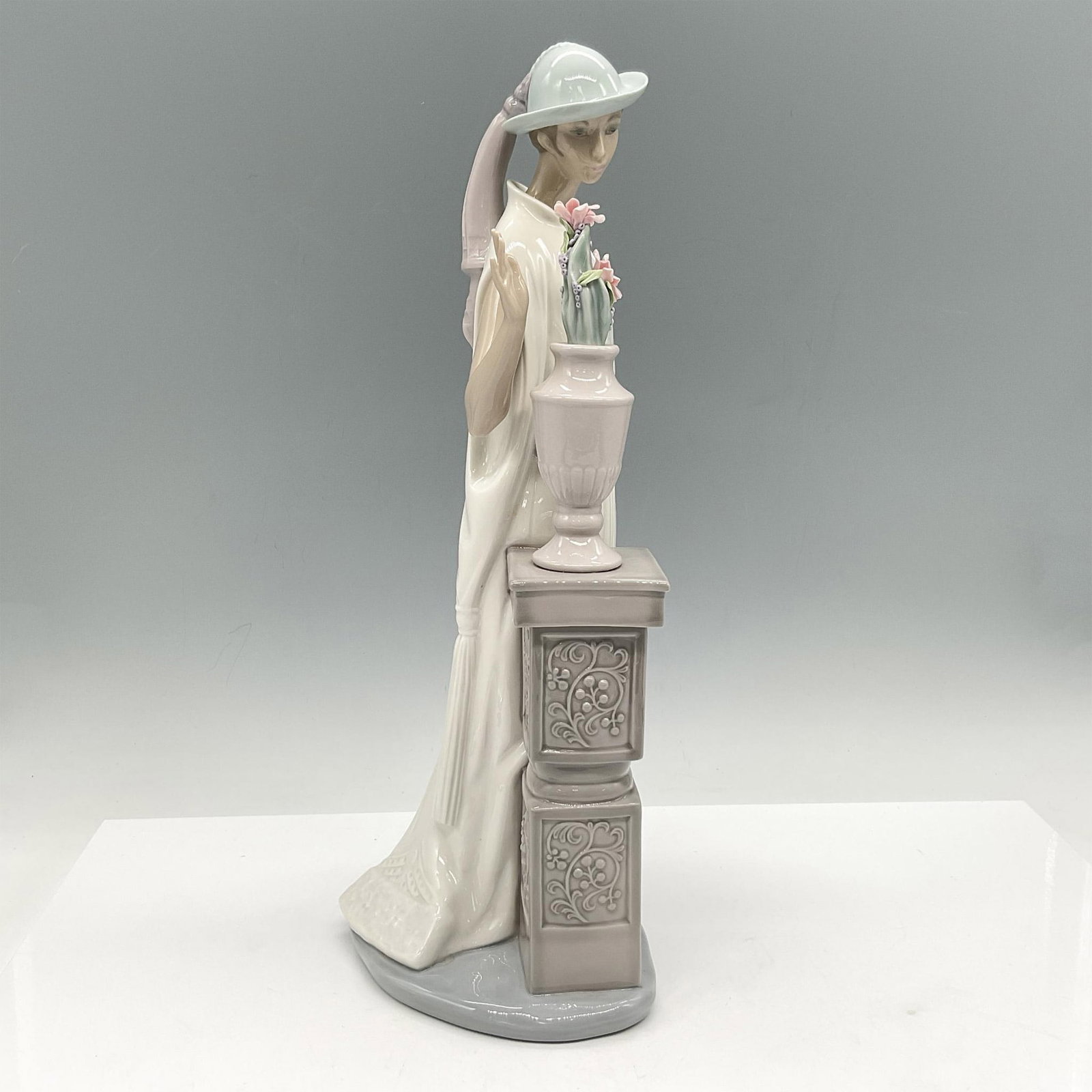Lady Grand Casino 01005175 - Lladro Porcelain Figurine: Glossy elegant figure dressed in all white with pale blue hat. Lladro backstamp. This item has its original box: 18"L x 7"W x 7"H. Artist: Vincente Martinez Issued: 1982-1995 Dimensions: 6"L x 5"W x 1