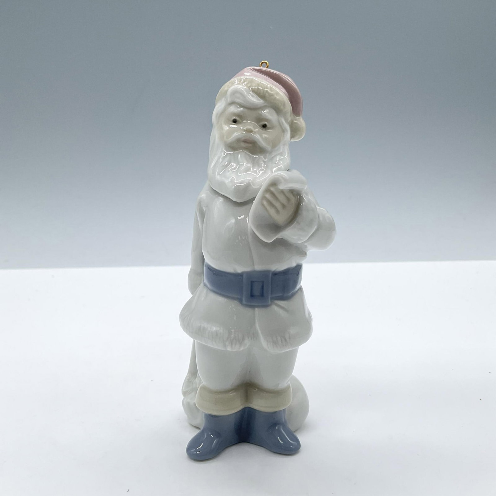 Santa Claus 1005842 - Lladro Porcelain Ornament: Glossy porcelain. Features a Santa Claus in a white suit and pale colors. Lladro backstamp. Includes the original box, dimensions: 4.25''L x 5''W x 2.5''H. Artist: Joan Coderch Issued: 1991 - 1993 Dim