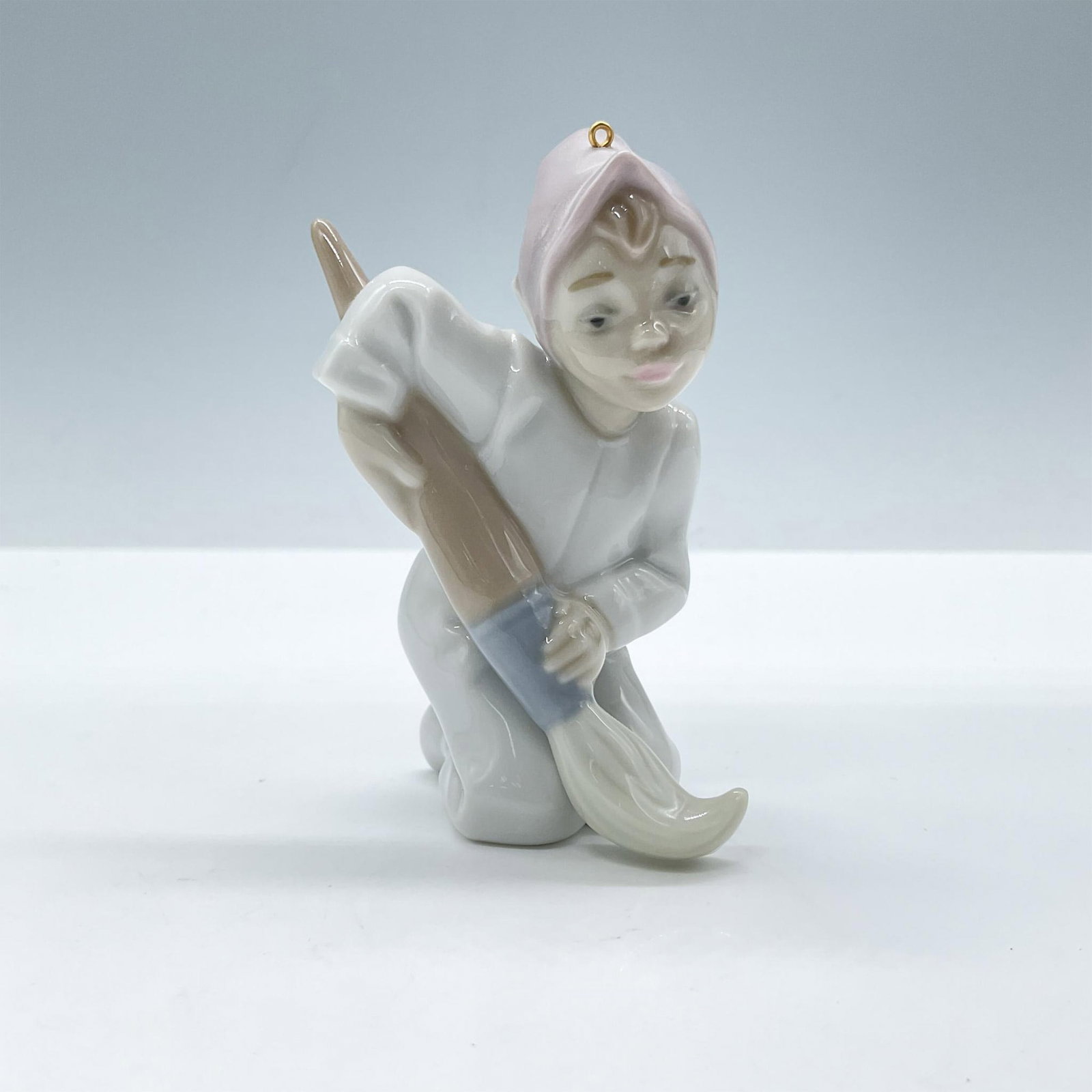Elf 1005938 - Lladro Porcelain Ornament: Glossy porcelain. Features a little elf in pale colors holding a brush. Lladro backstamp. Includes the original box, dimensions: 4''L x 5''W x 2.5''H. Artist: Joan Coderch Issued: 1992 - 1993 Dimensio
