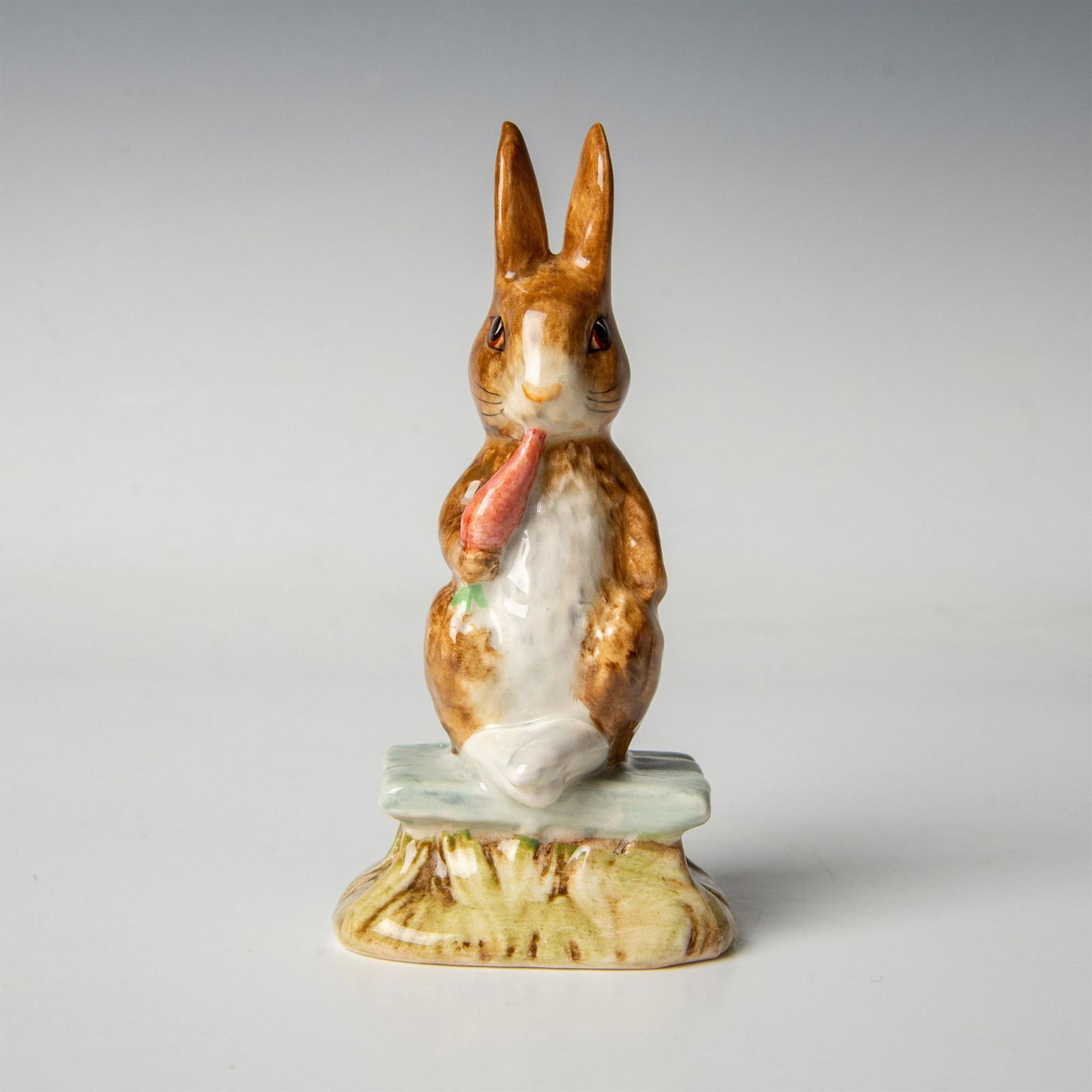 Beswick Beatrix Potter Figurine, Fierce Bad Rabbit: Modeled in white and brown fur with his feet out, sitting on a green bench. Includes the original box, dimensions: 2''L x 2.5''W x 5''H. Beswick backstamp. Artist: David Lyttleton Issued: 1977 - 1980