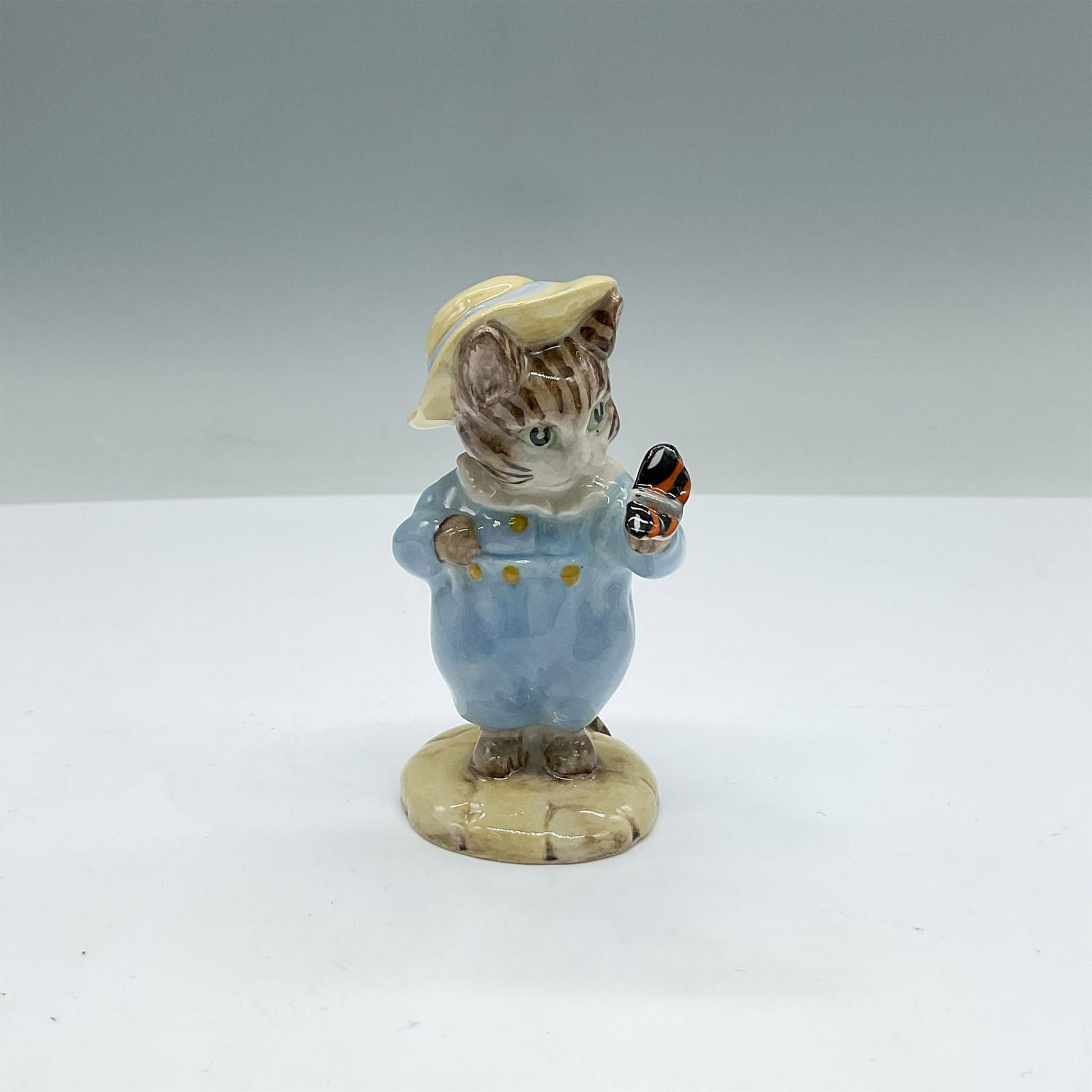 Beswick Beatrix Potter Figurine, Tom Kitten and Butterfly: Adorable character modelled in blue clothes holding an orange and black butterfly. Includes the original box. Box measures: 3''L x 3.25''W x 4.5''H. Beswick backstamp. Issued: 20th century Dimensions: