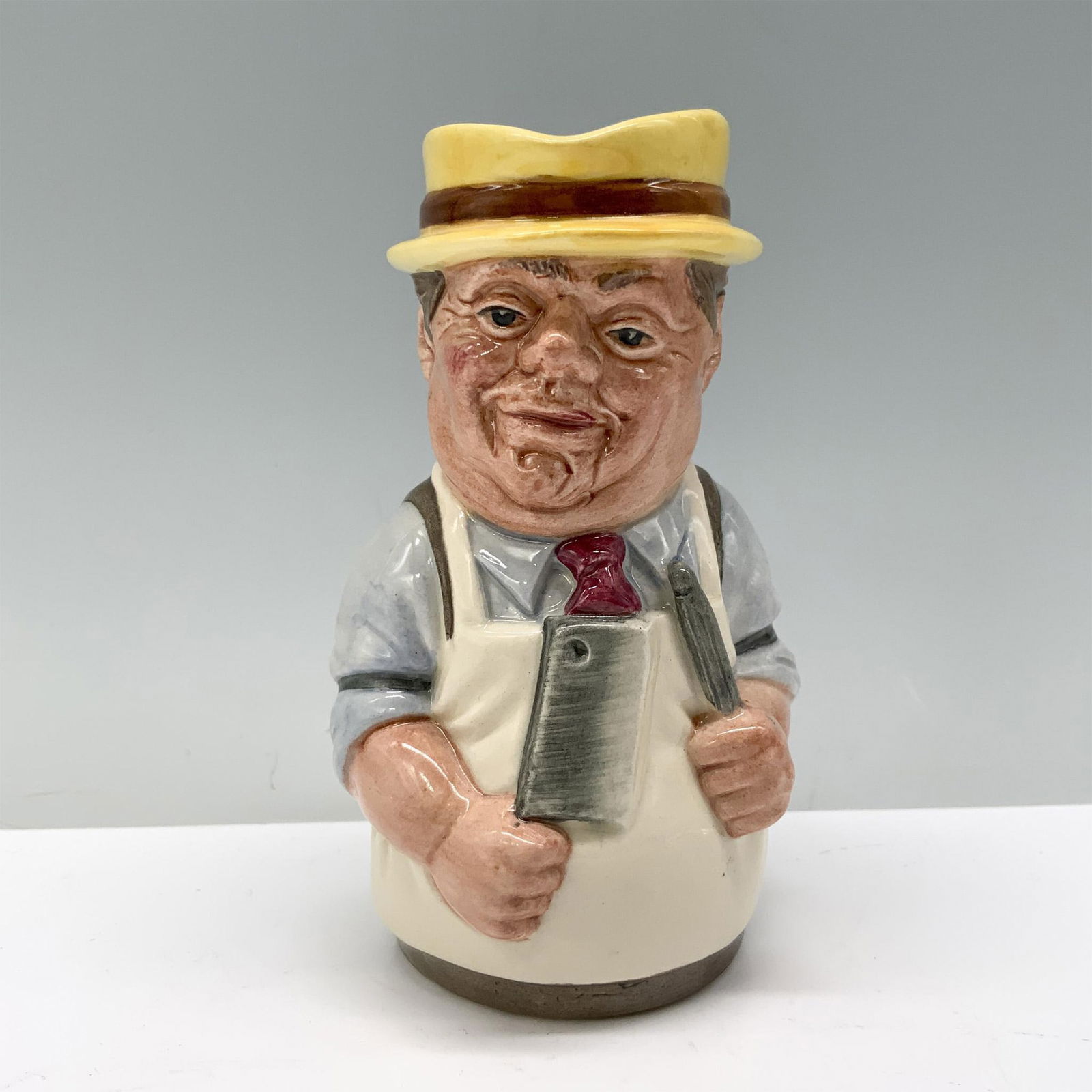 Mr. Brisket the Butcher D6743 - Royal Doulton Toby Jug: Royal Doulton backstamp. Artist: William K. Harper Issued: 1986 - 1991 Dimensions: 4"H Manufacturer: Royal Doulton Country of Origin: England