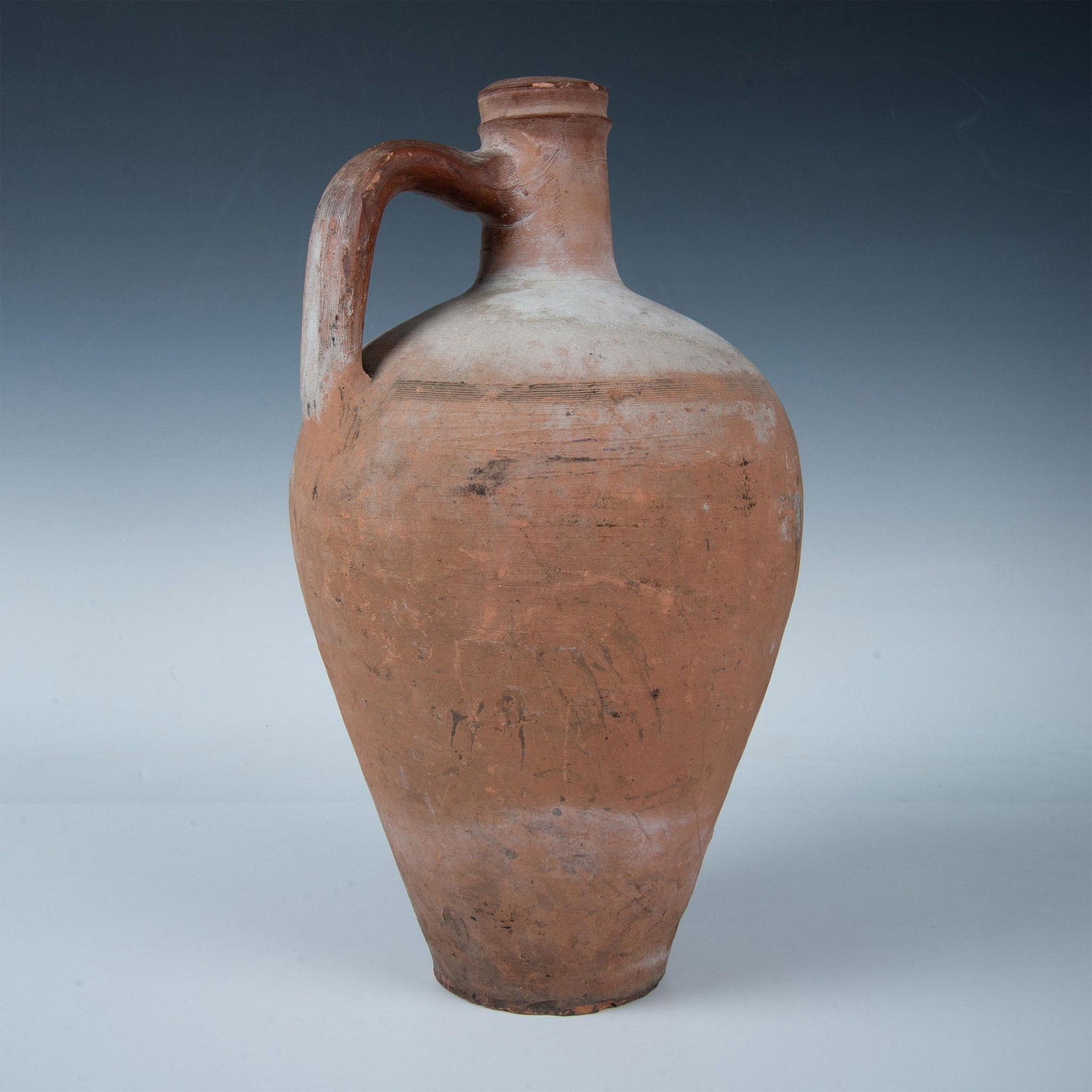 Antique Large Turkish Style Terracotta Storage Jug: Hand made earthenware handled vessel jar with horizontal turning grooves. A container, such as this, would be used to store liquids, like wine or oil. Dimensions: 9"W x 15.25"H